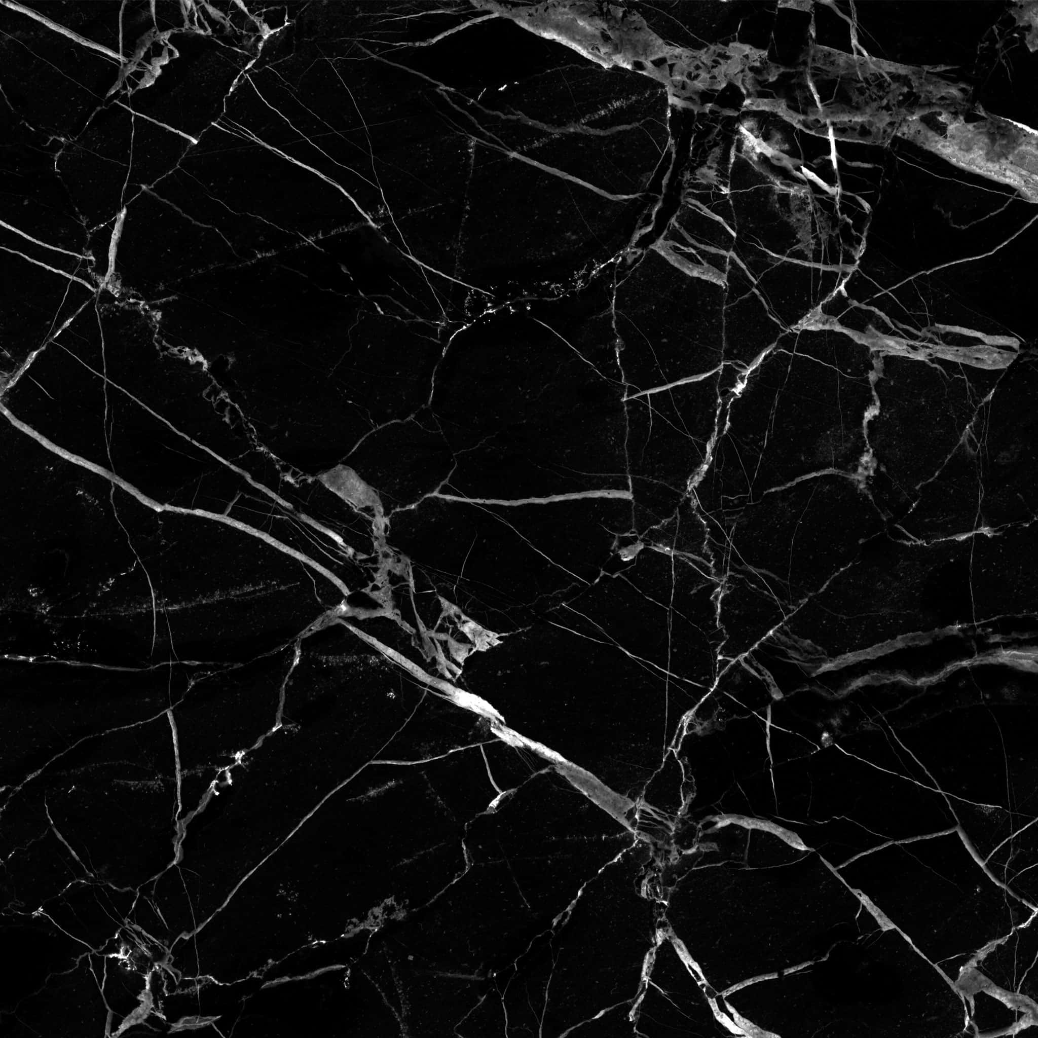 Black Marble 桌布 壁紙 — 光澤黑色大理石的近距離特寫，帶有複雜的白色紋理，營造出奢華而戲劇性的圖案。