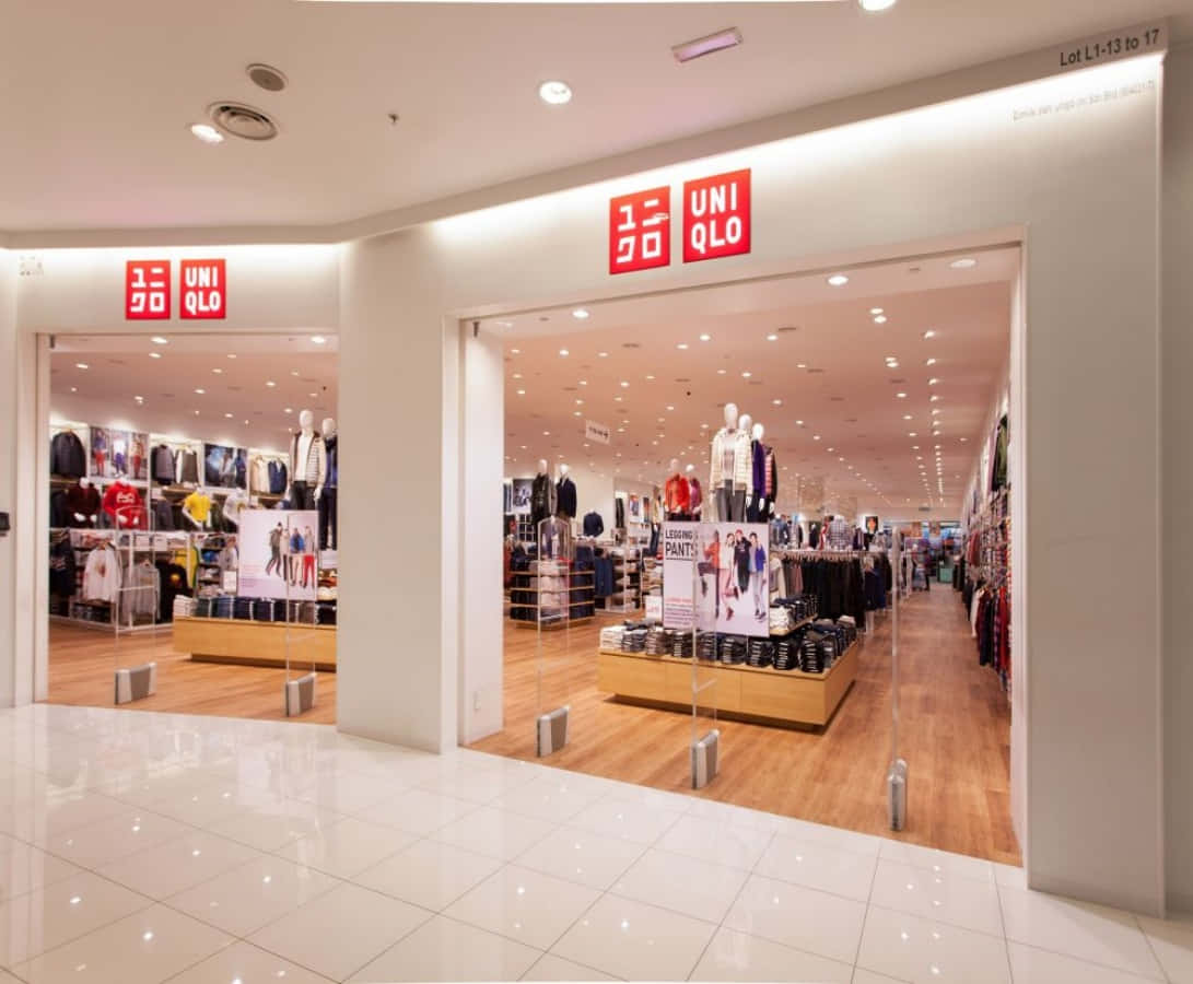 Uniqlo 桌布 壁紙 — 光線充足的 Uniqlo 店鋪入口，紅色標誌招牌和木地板透過玻璃門清晰可見。