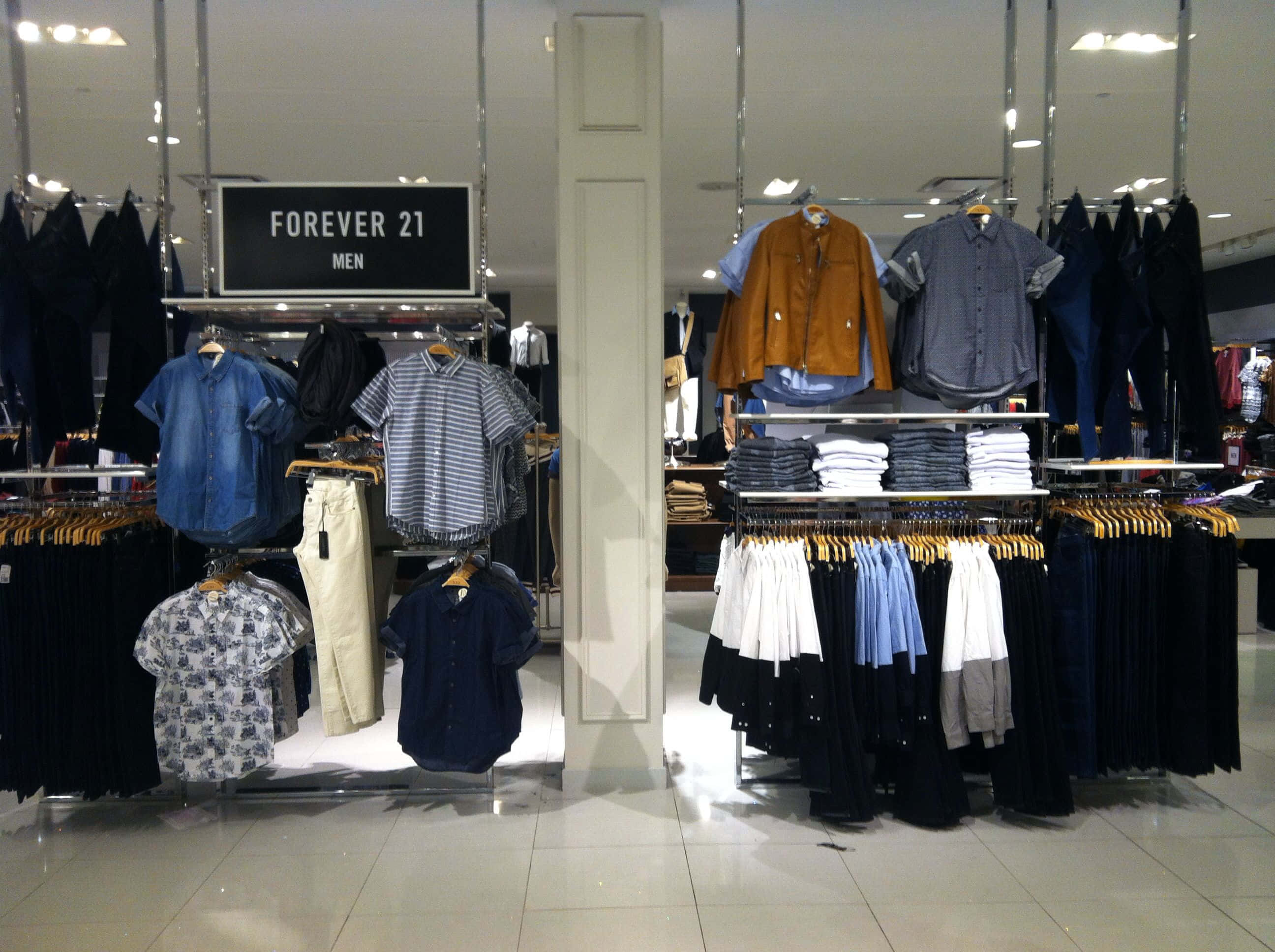 永遠21 桌布 壁紙 — 光線充足的Forever 21男裝店在明亮的頂燈下展示襯衫、褲子和外套的貨架。