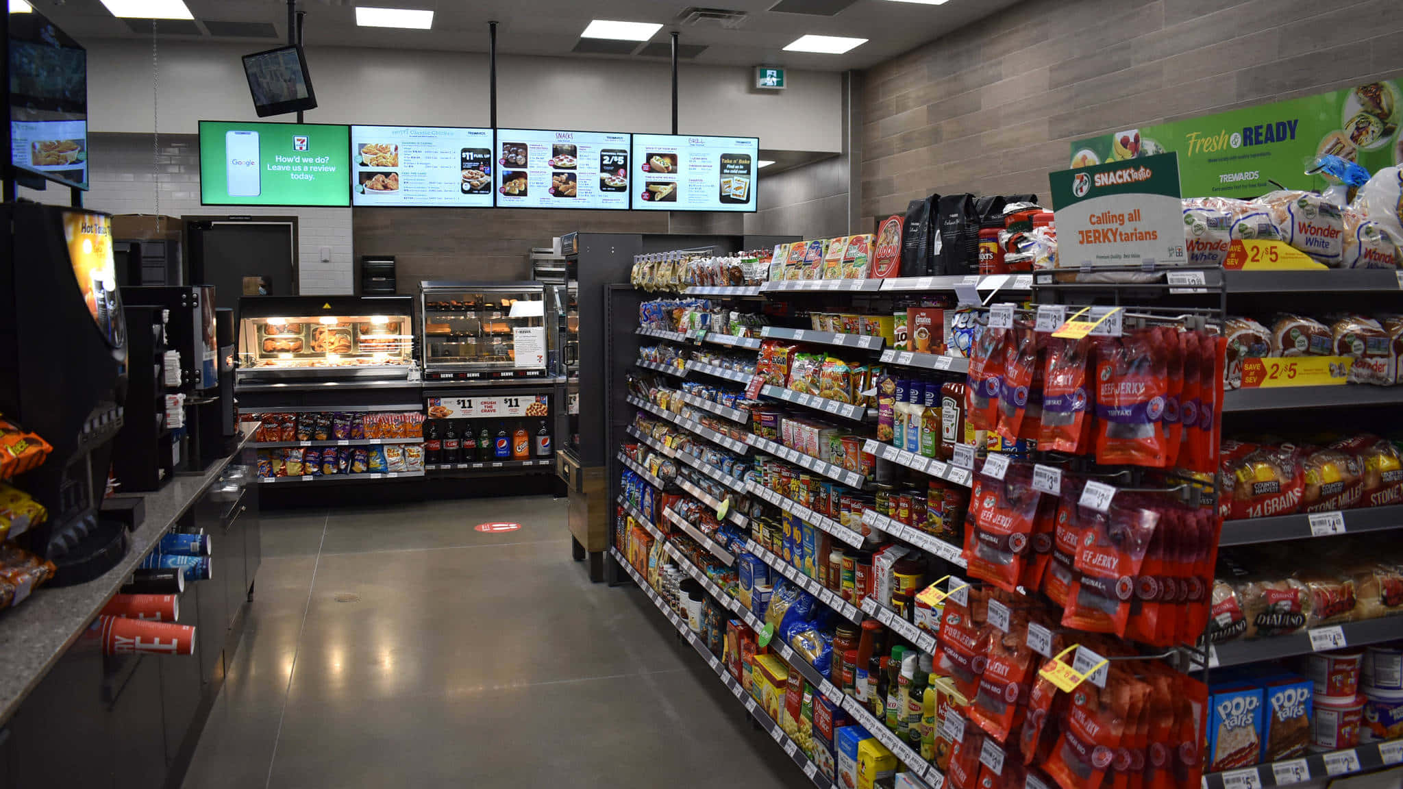7-ELEVEN 桌布 壁紙 — 光線充足的便利店走道，在明亮的頂燈下陳列著色彩繽紛的零食和飲料。