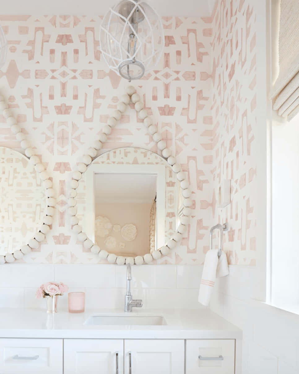 Bathroom Decor 桌布 壁紙 — 光線充足的浴室，配有粉紅色幾何圖案壁紙、珠飾鏡子和白色櫥櫃，在自然光下。