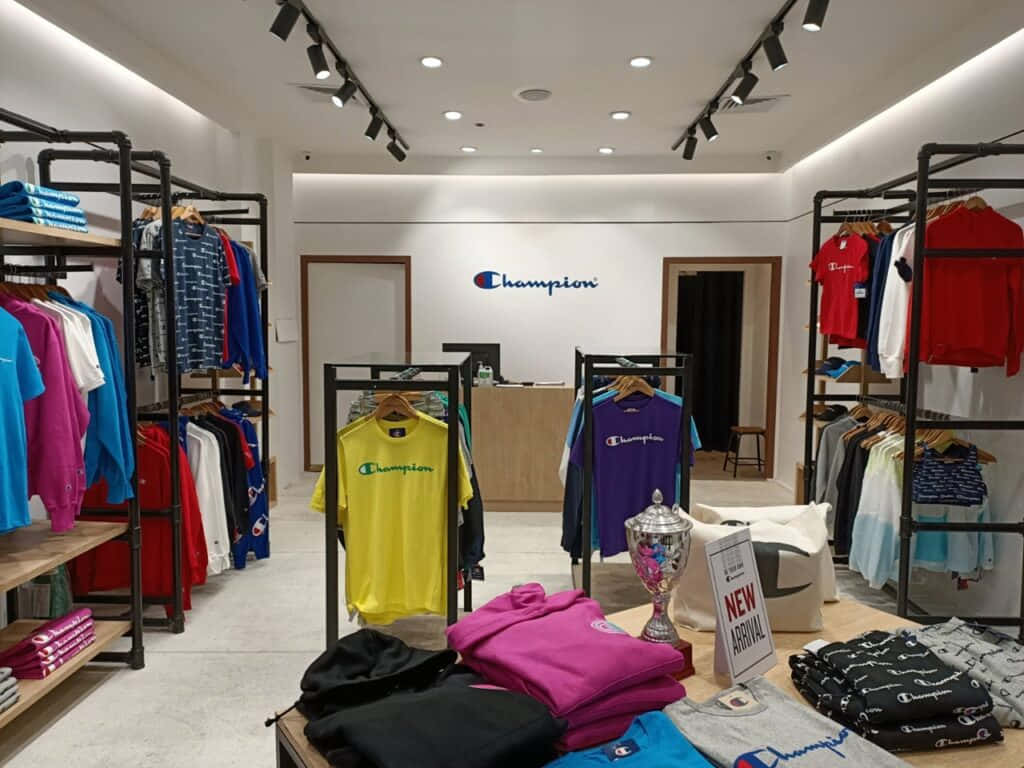 Champion 桌布 壁紙 — 光線明亮的Champion服裝店，展示著色彩繽紛的衣架和一個獎盃。