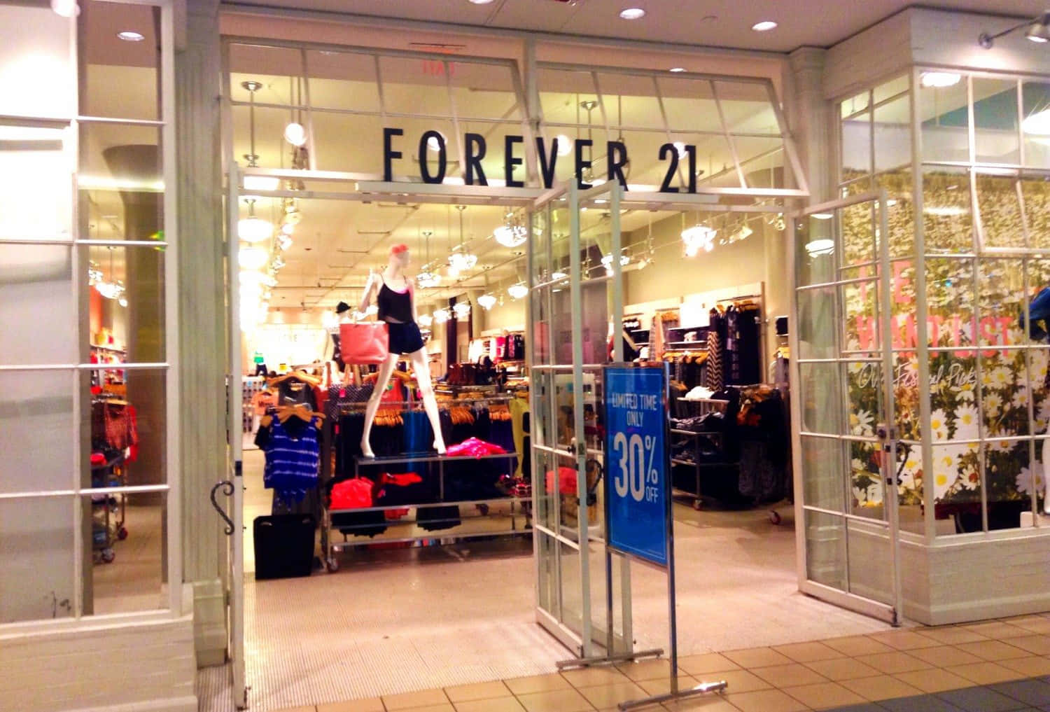 永遠21 桌布 壁紙 — 光線明亮的Forever 21商店入口，玻璃門敞開，展示人體模型、貨架和30%折扣標誌。
