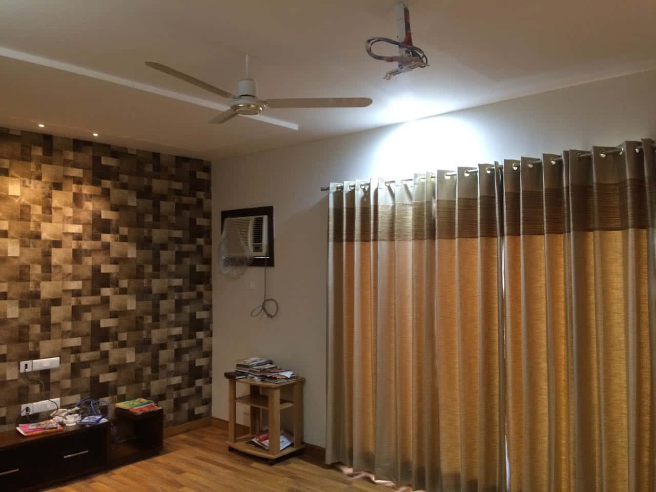 Curtains 桌布 壁紙 — 光線明亮的客廳，鋪有木地板、紋理牆壁、窗簾和吊扇，在明亮的頭頂燈光下營造溫暖氛圍。