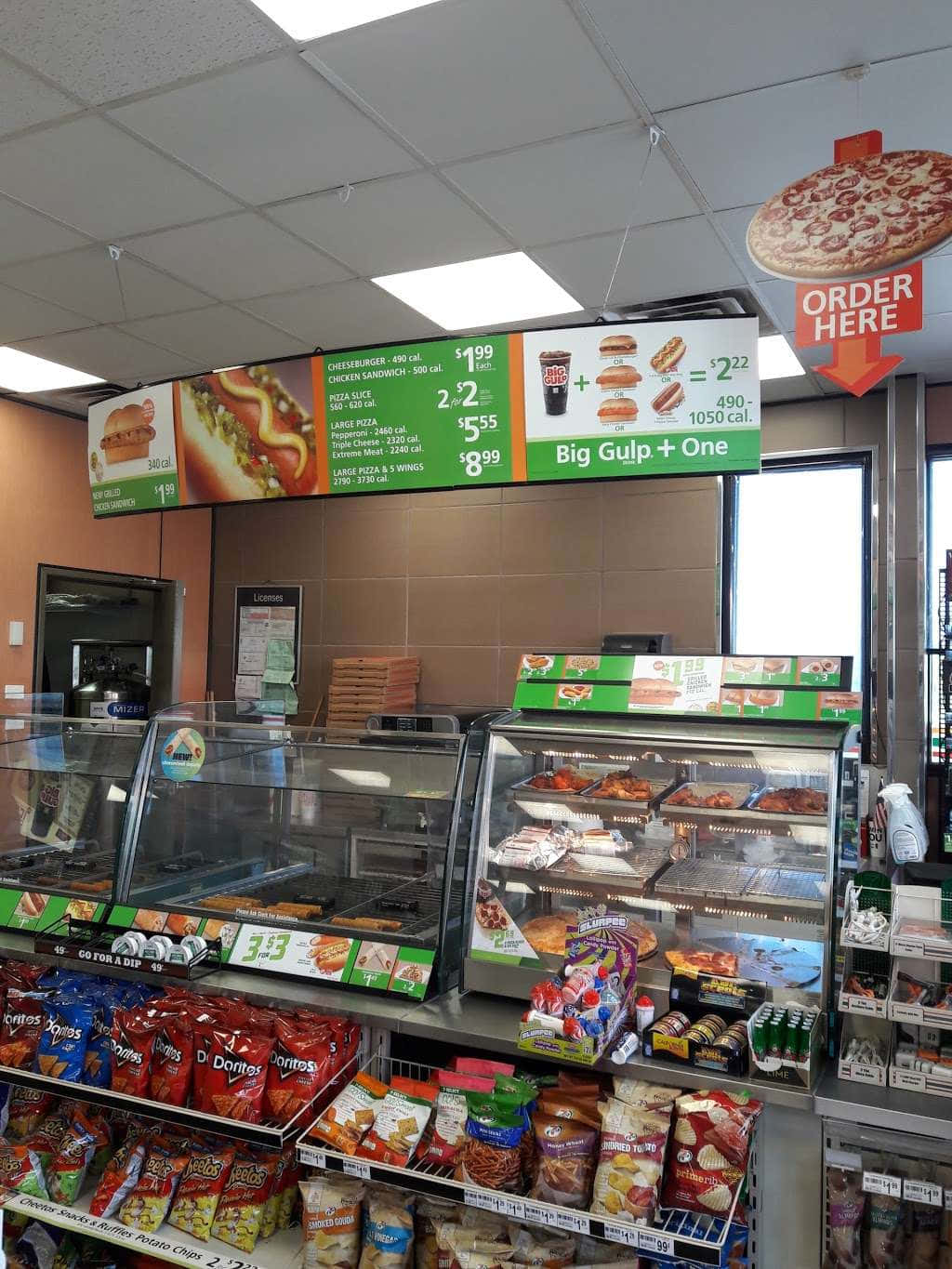 7-ELEVEN 桌布 壁紙 — 光線明亮的速食餐廳內部，玻璃展示櫃裝滿食物，綠色菜單板顯示價格和套餐。