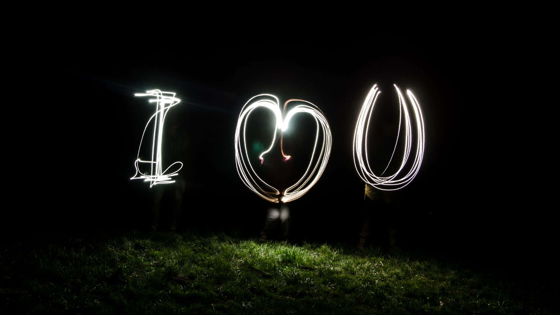 Beautiful Love 桌布 壁紙 — 光繪在黑暗夜空下的草地上形成發光白色軌跡的字母 I O U。
