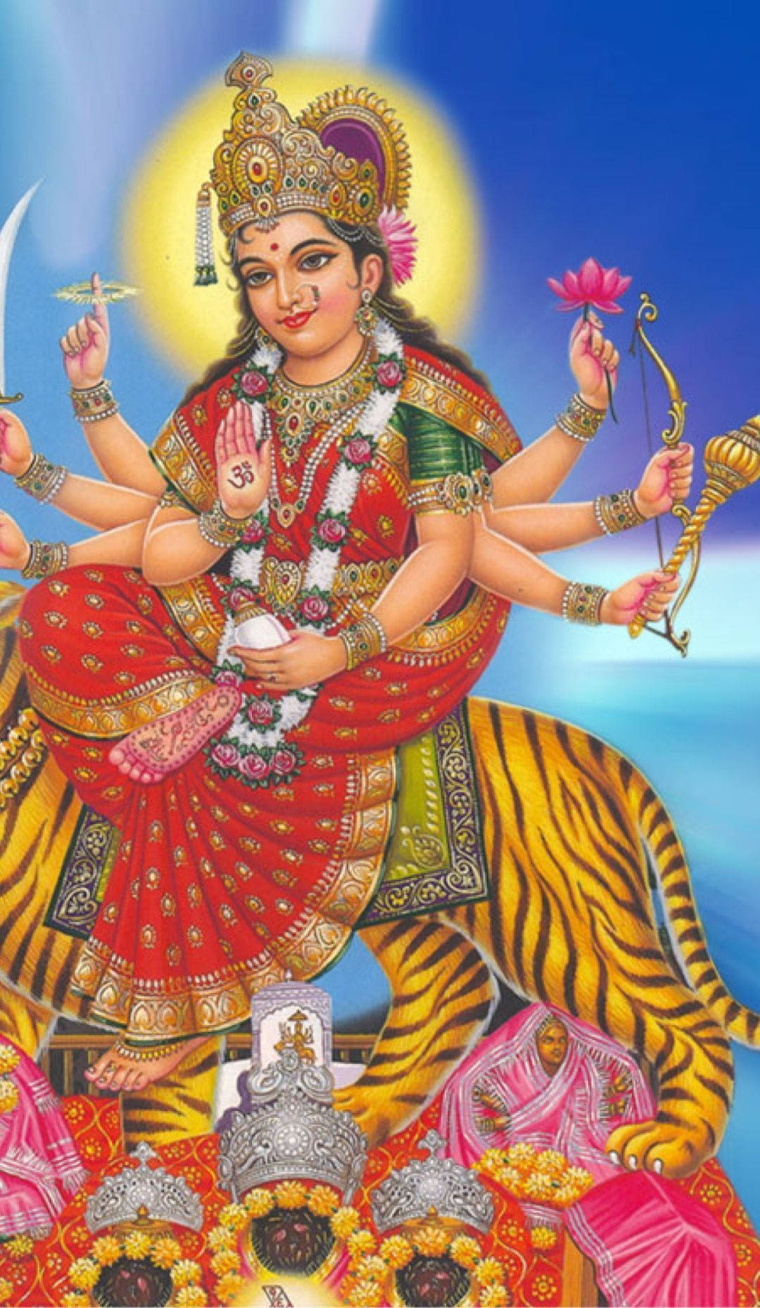 Indian 桌布 壁紙 — 光芒四射、多臂的女神杜爾迦身穿紅金服飾，騎著老虎，背景是閃耀的藍天。