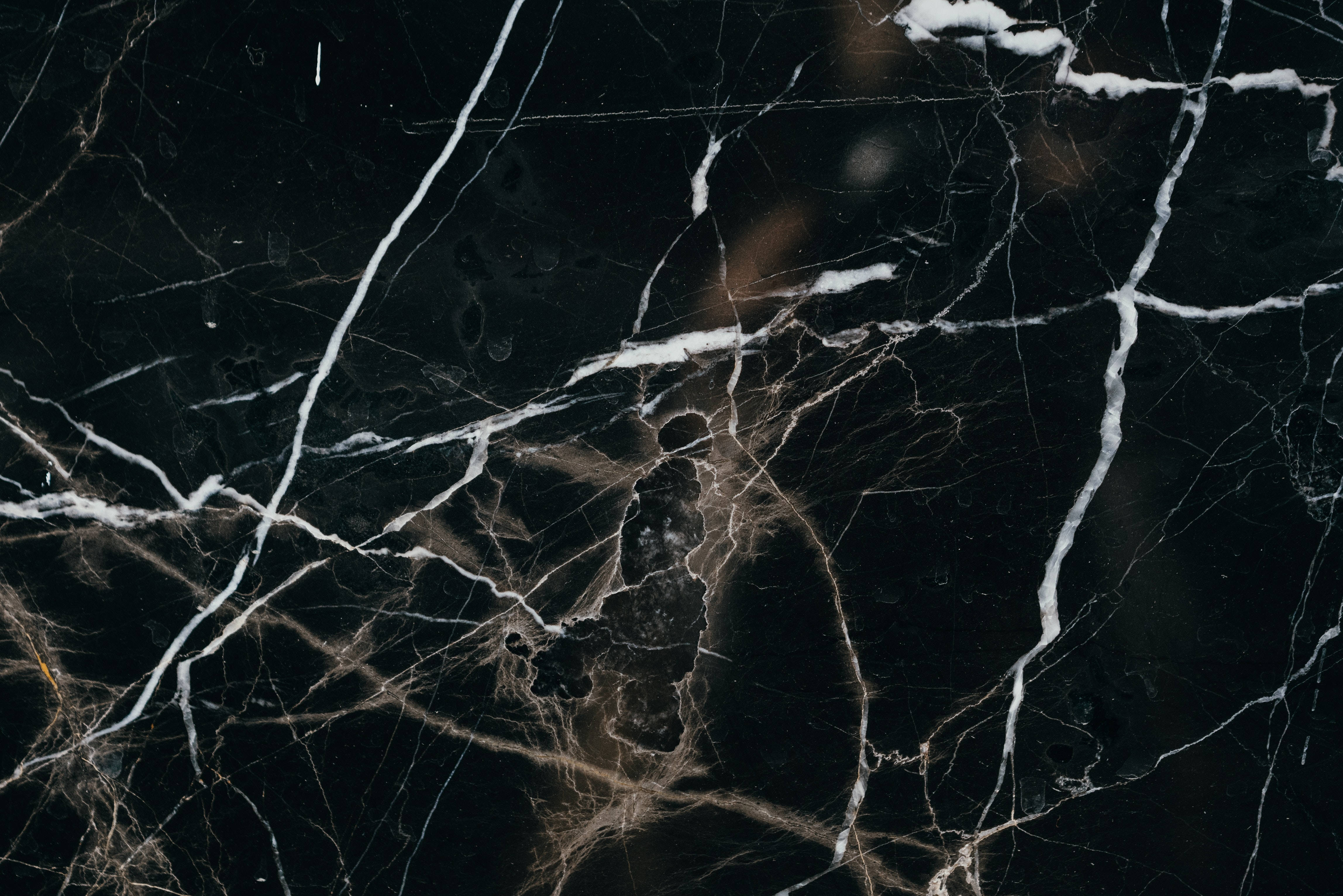 Black Marble 4K 桌布 壁紙 — 光面黑色大理石特寫，帶有醒目的白色和金色紋理，營造出優雅的自然圖案。