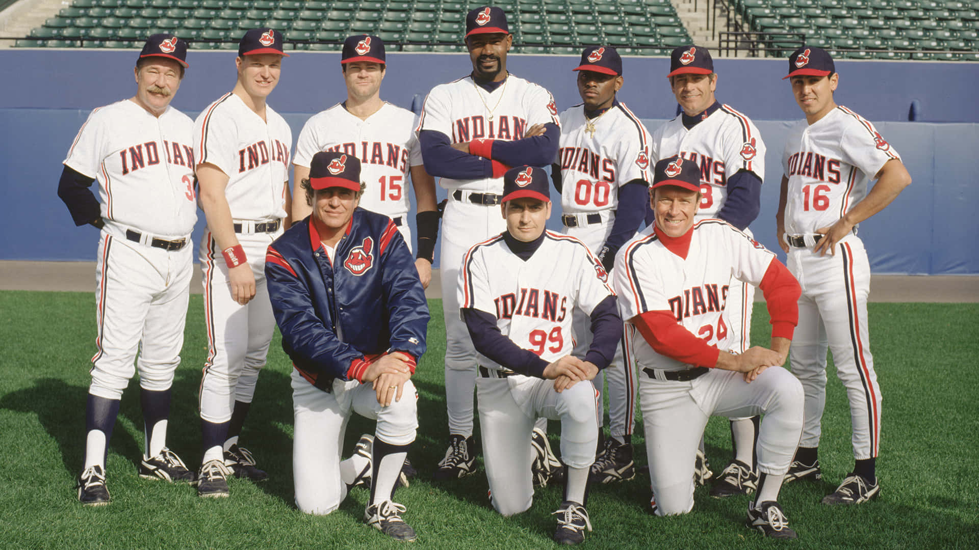 Major League Movie 桌布 壁紙 — 克里夫蘭印地安人棒球隊穿著復古球衣，在陽光明媚的球場上擺姿勢，背景是體育場座位。