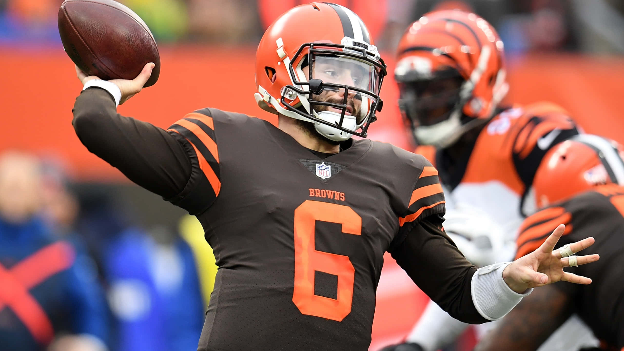 Baker Mayfield 桌布 壁紙 — 克里夫蘭布朗隊的四分衛身穿棕色和橙色球衣，在日間比賽中準備擲出美式足球。
