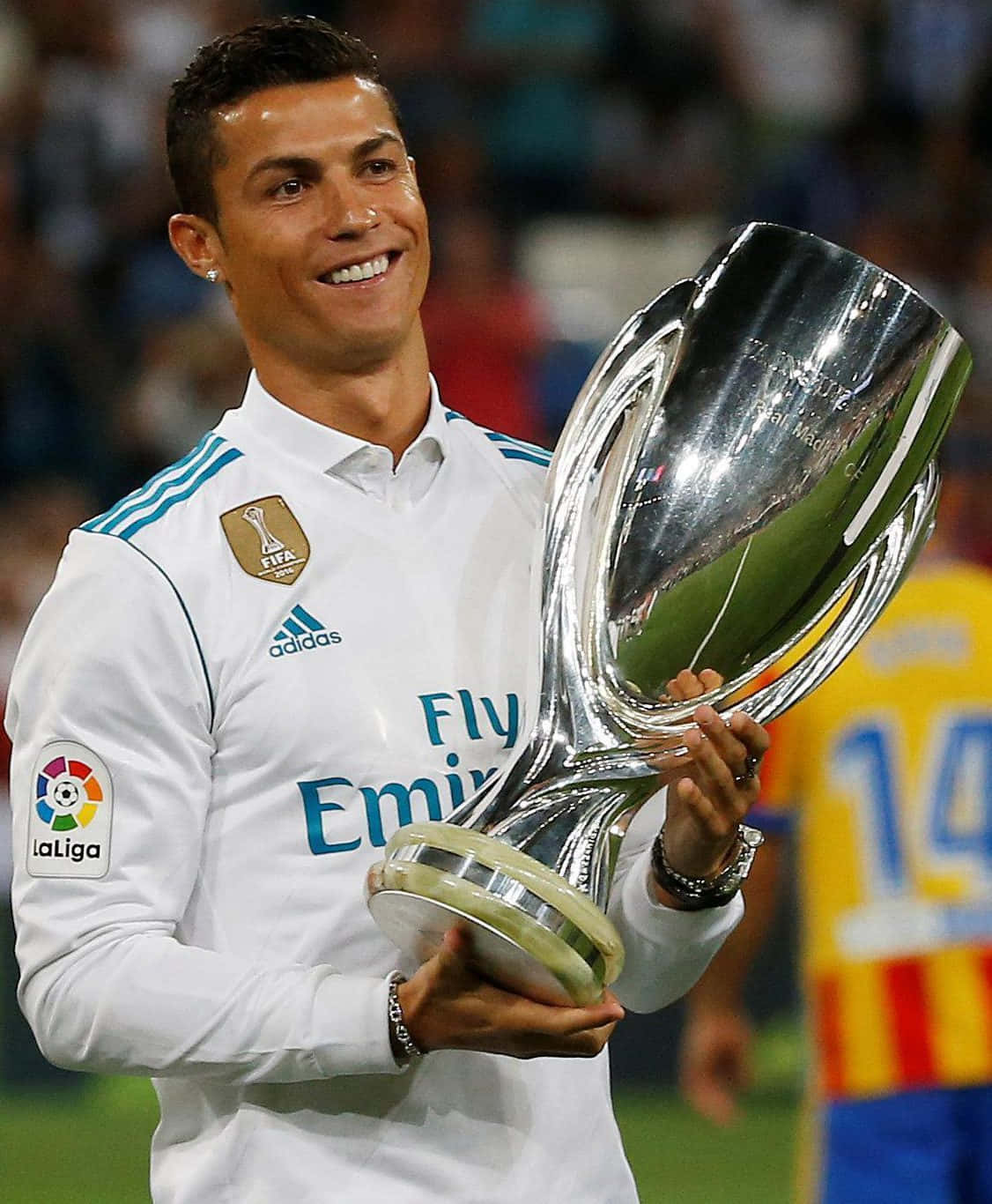 Ronaldo 桌布 壁紙 — 克里斯蒂亞諾·羅納度在一個充滿歡呼聲的體育館中，自豪地微笑著，手持閃亮的銀色獎盃。