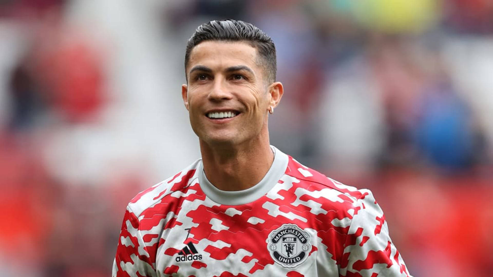 Ronaldo 桌布 壁紙 — 克里斯蒂亞諾·羅納度在球場上穿著紅白曼聯球衣自信地微笑。