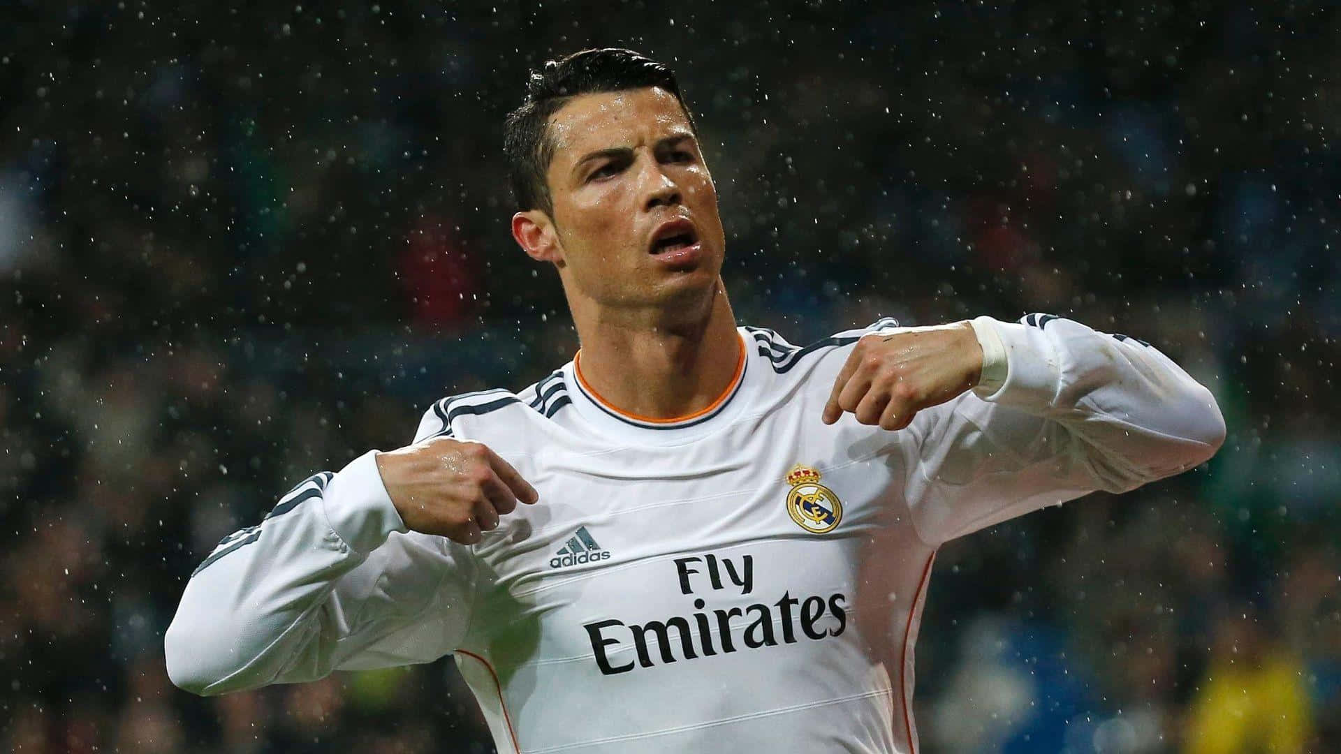 Ronaldo 桌布 壁紙 — 克里斯蒂亞諾·羅納度在球場燈光下，身穿白色皇家馬德里球衣，在雨中慶祝。