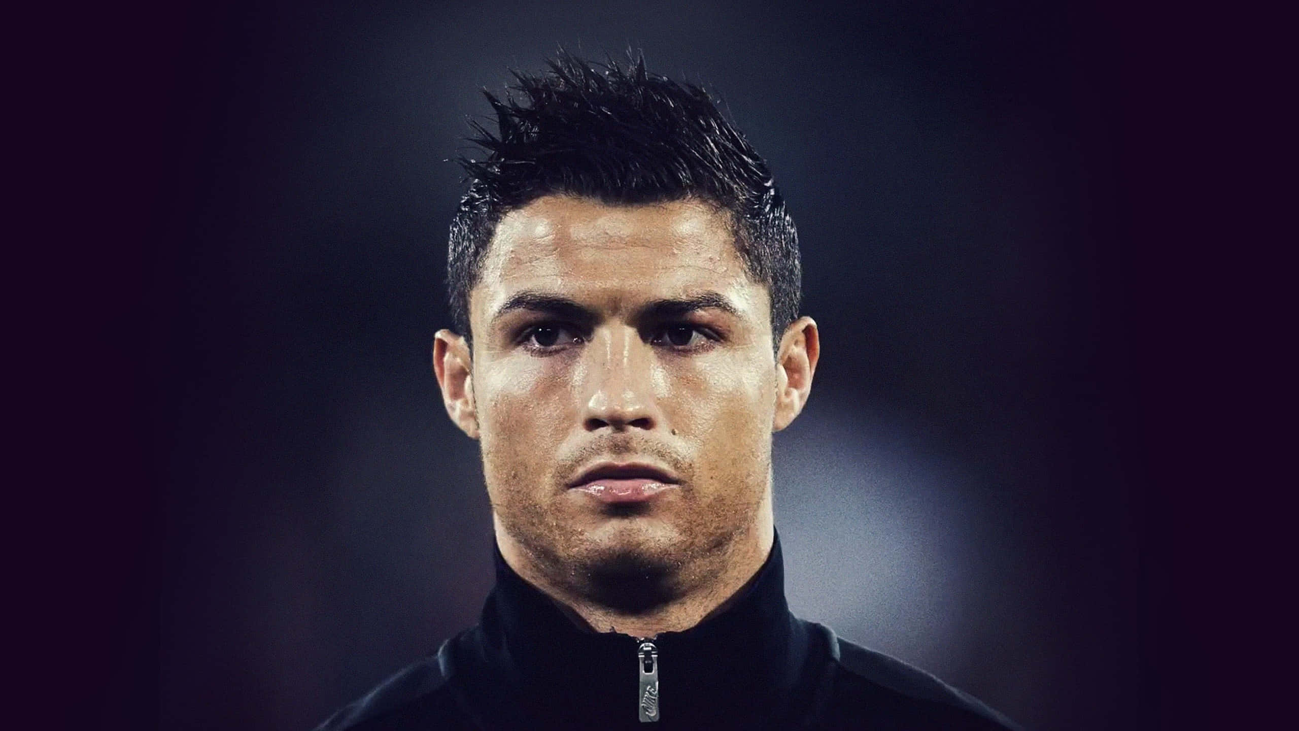 Cristiano Ronaldo 足球 桌布 壁紙 — 克里斯蒂亞諾·羅納度的特寫肖像，眼神銳利，背景為暗色模糊效果。