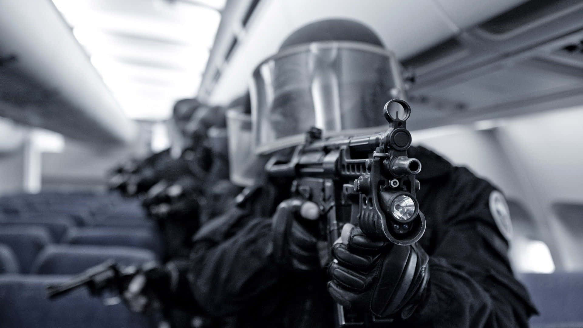 Tactical 桌布 壁紙 — 全副武裝的戰術警員在昏暗的飛機艙內瞄準步槍。