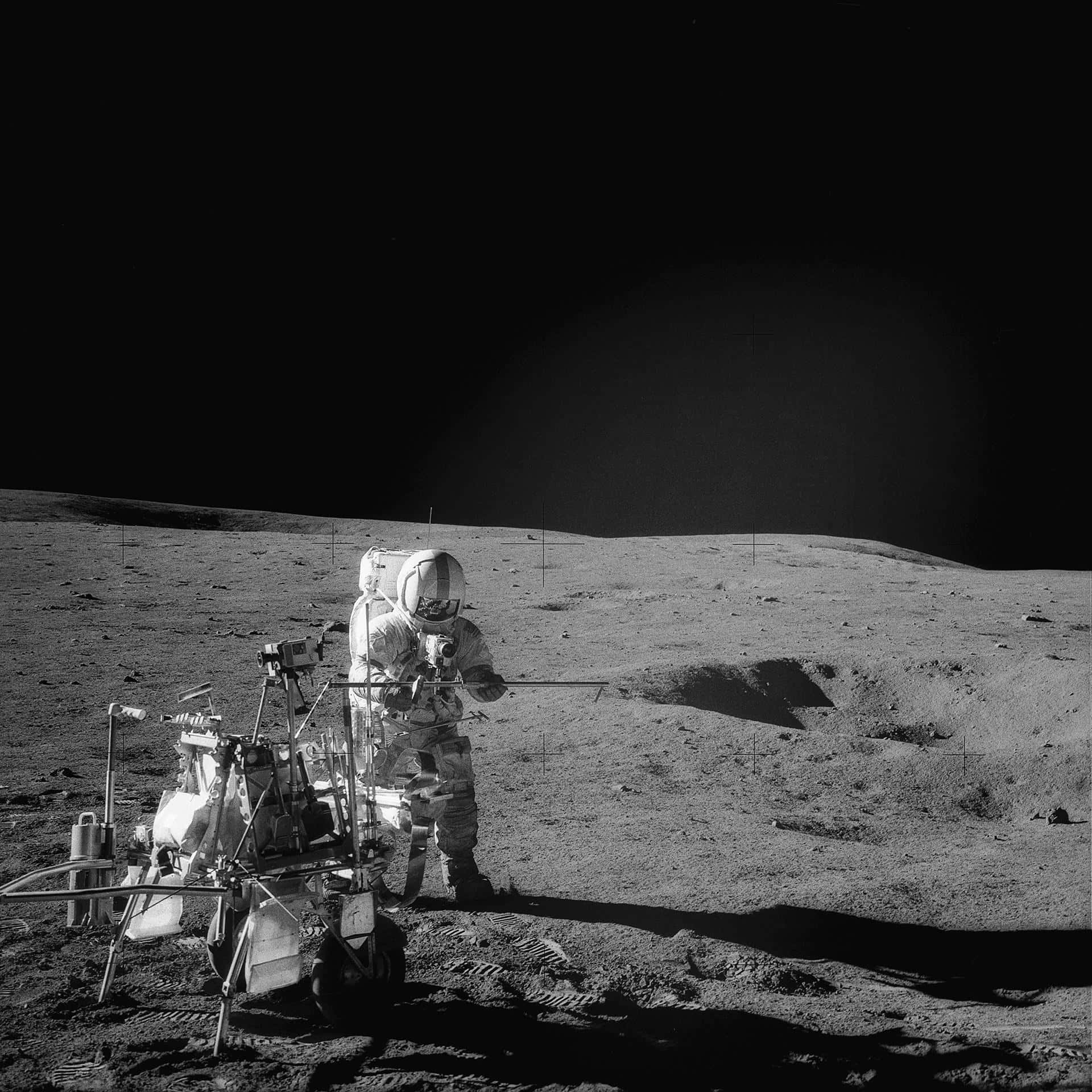 Moon Landing 桌布 壁紙 — 全副裝備的太空人站在荒蕪的月球表面，旁邊是月球車，上方是漆黑的天空。
