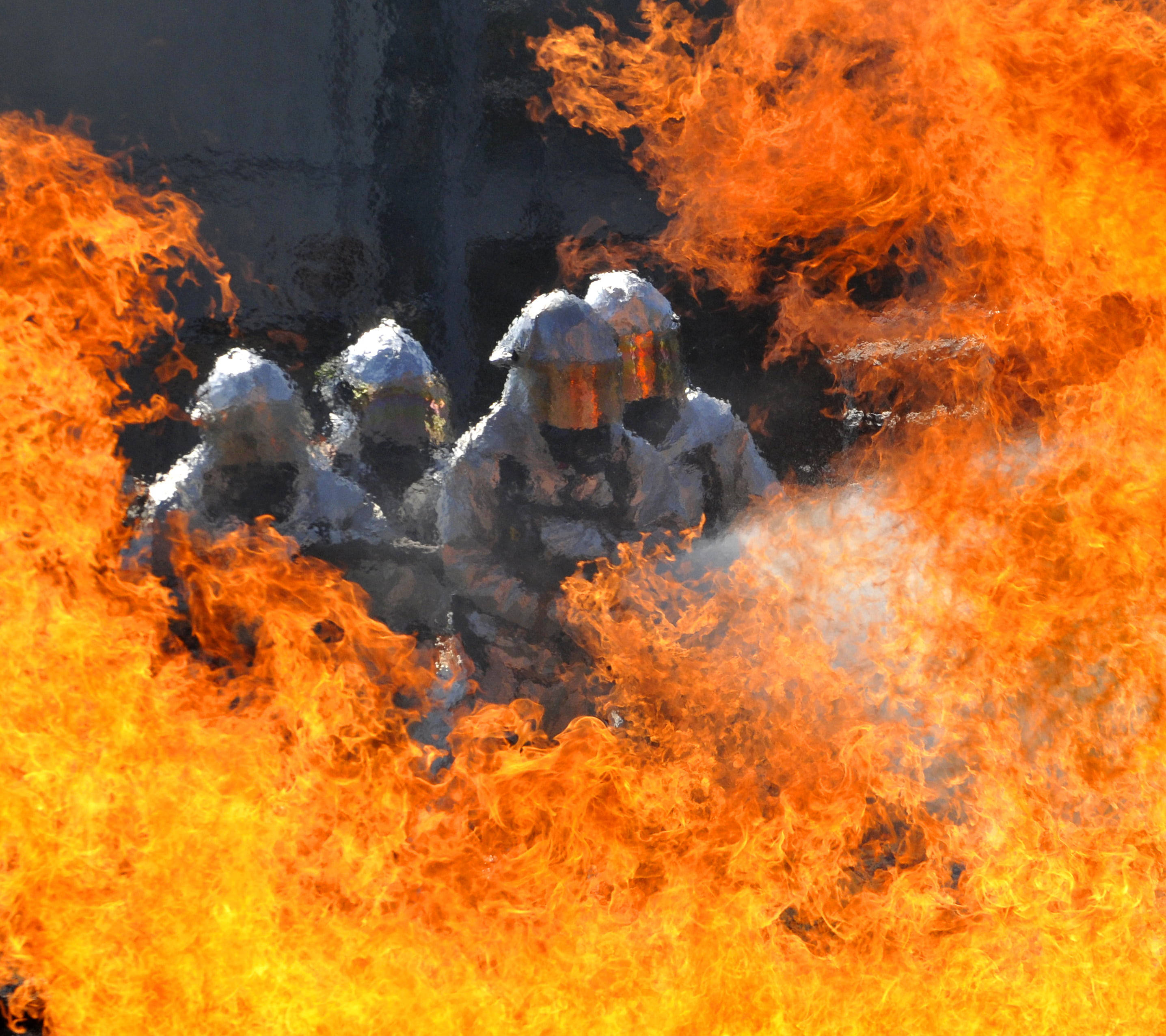 Firefighter 桌布 壁紙 — 全副裝備的消防員正在與吞噬建築物的猛烈火焰搏鬥，濃煙在他們周圍翻騰。