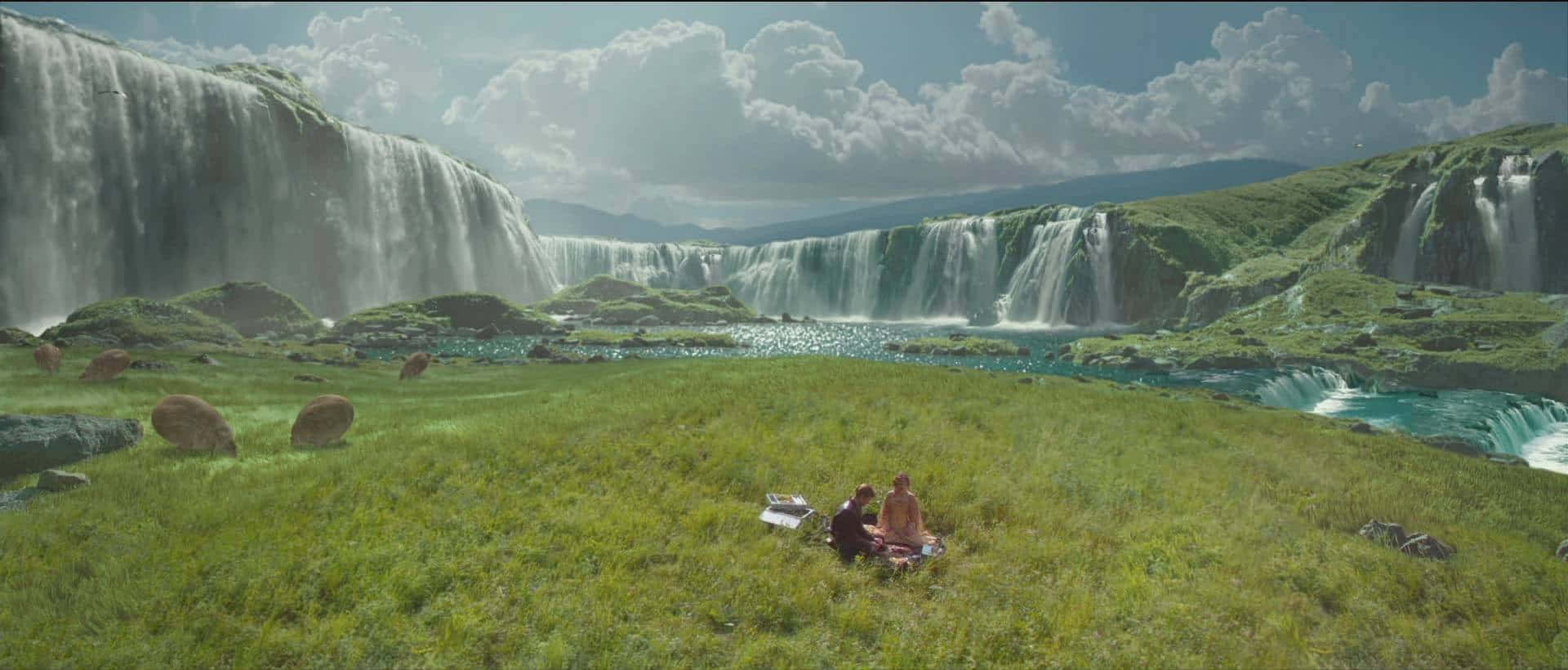 Naboo 桌布 壁紙 — 兩人在明亮的陰天下，在巨大瀑布前的草地上放鬆。