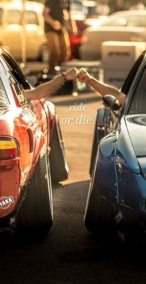 Ride Or Die 桌布 壁紙 — 兩人在賽車中透過打開的車窗在金色夕陽光下碰拳。