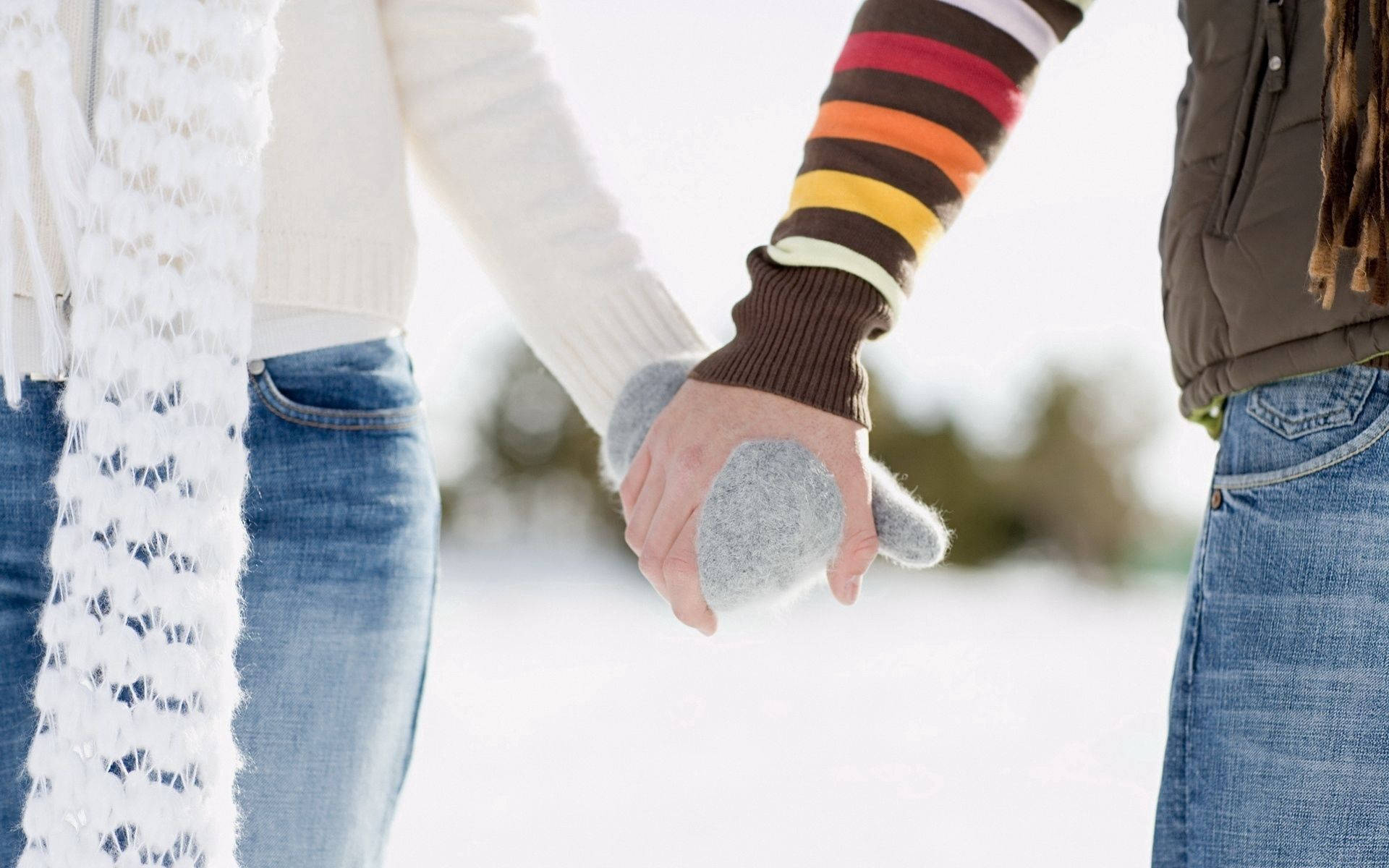 Friendship 桌布 壁紙 — 兩人在雪地冬日天氣中手牽手，穿著舒適的冬裝和連指手套。