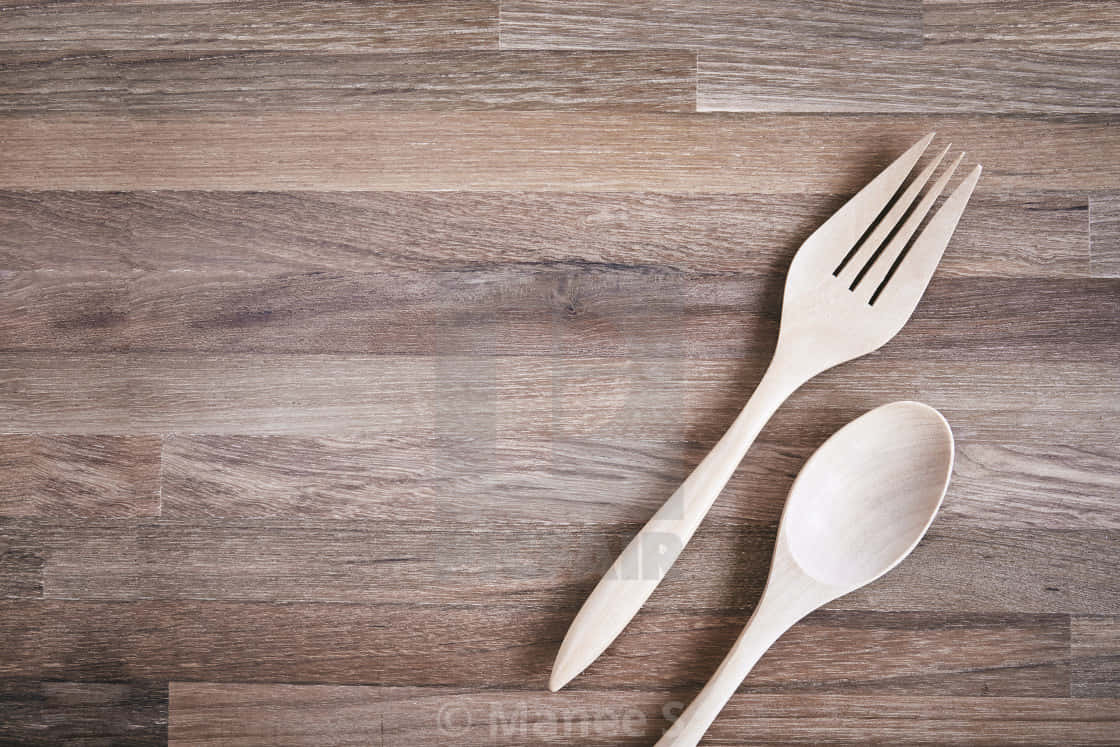 kitchen 桌布 壁紙 — 兩件輕木製餐具，叉子和湯匙，對角放置在深色紋理木質表面上。