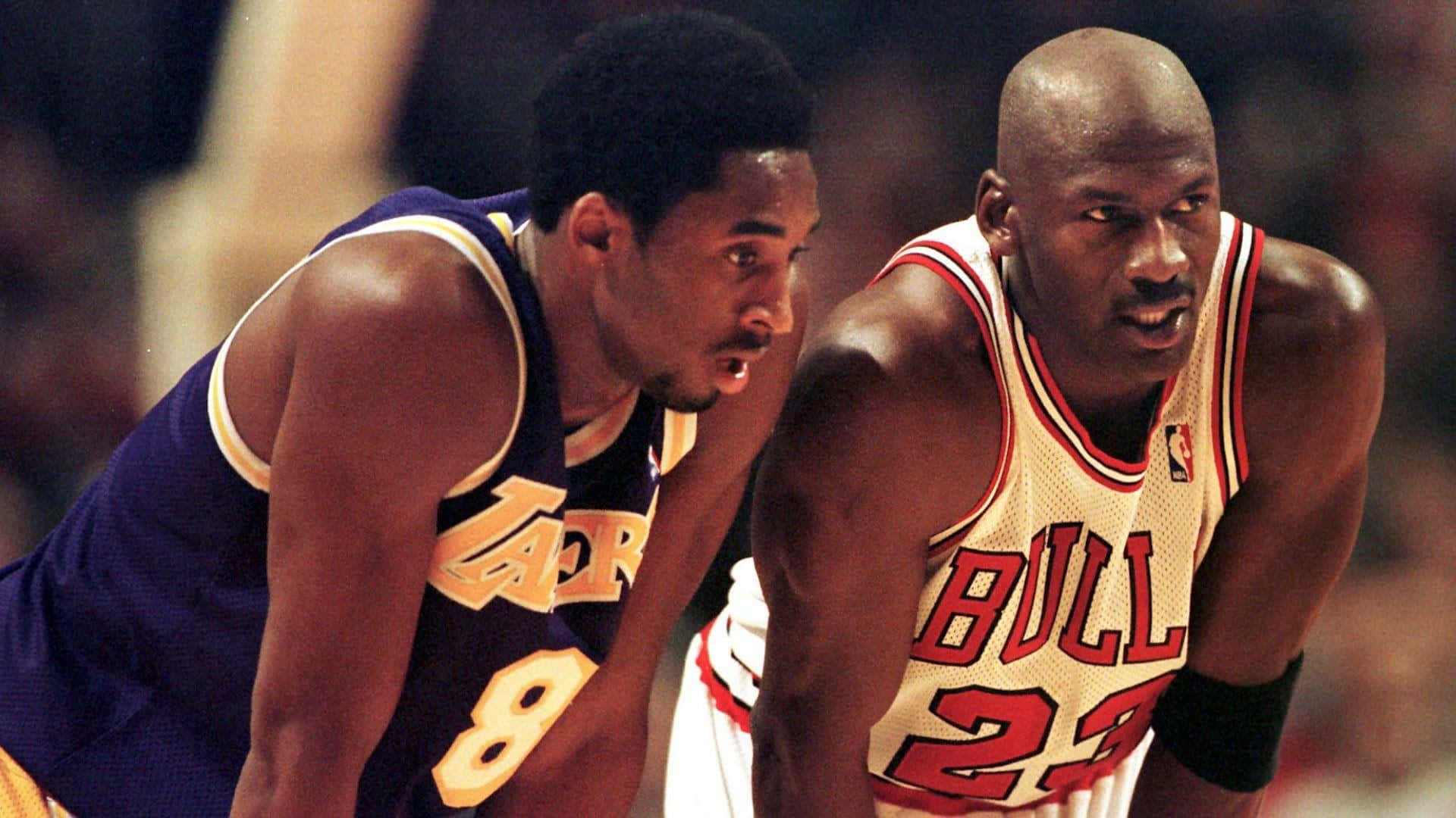 Jordan And Kobe 桌布 壁紙 — 兩位傳奇籃球運動員在比賽中高度專注，一位身穿紫色湖人球衣，另一位身穿白色公牛球衣。
