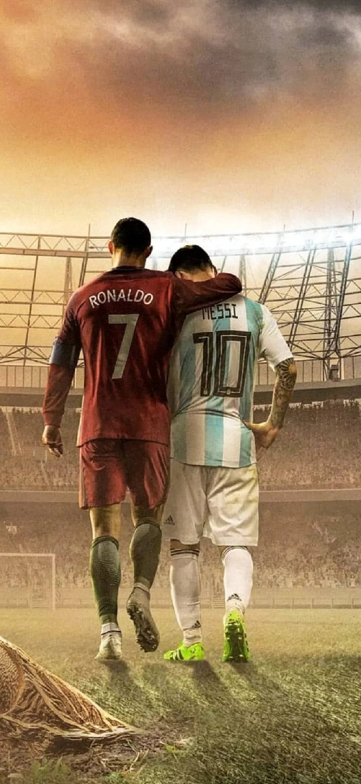 HD Football 桌布 壁紙 — 兩位傳奇足球員羅納度與梅西手挽手，在陽光明媚的球場上向球門走去。