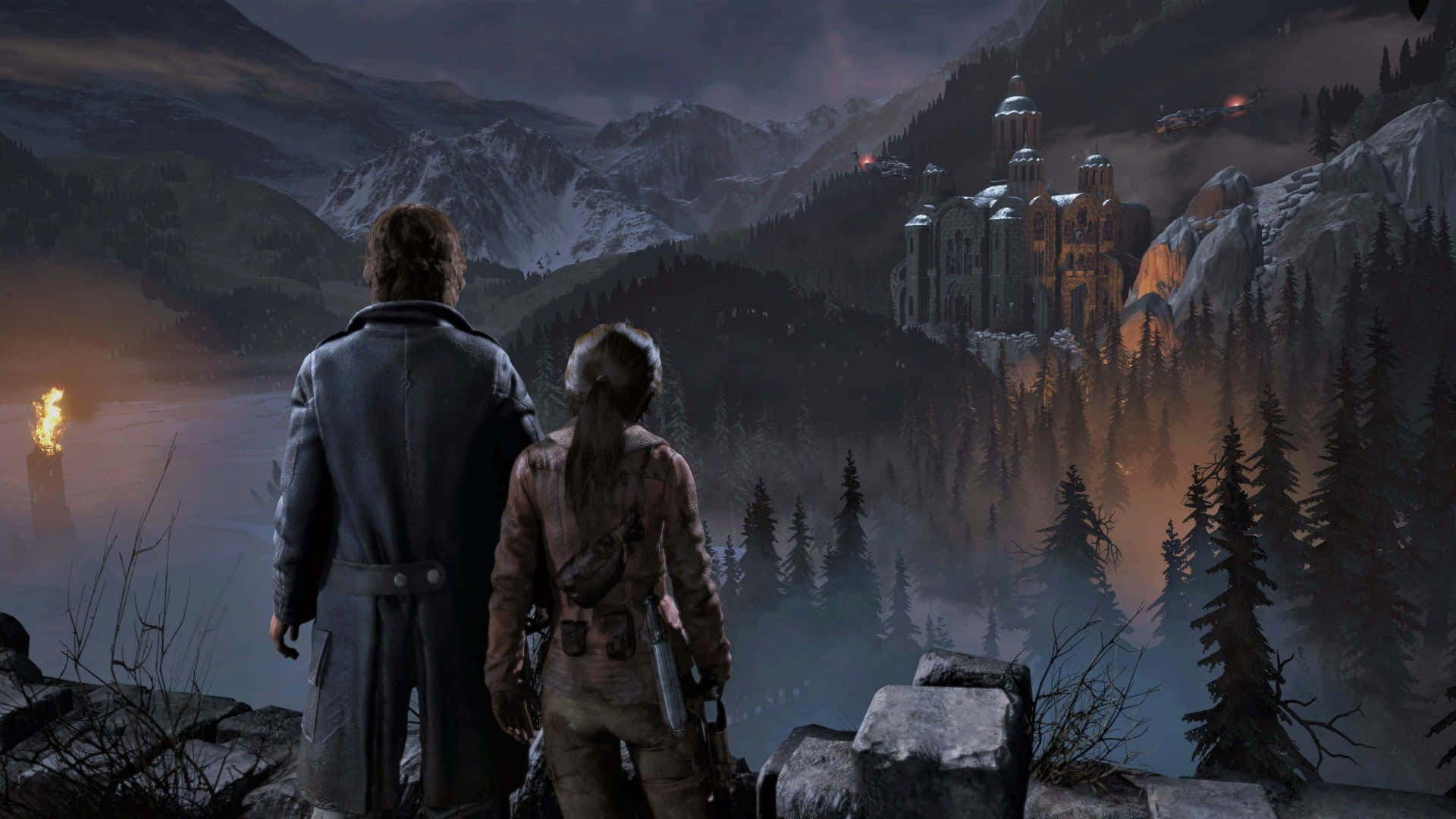 Lara Croft 桌布 壁紙 — 兩位冒險家站在懸崖上，俯瞰著一個迷霧籠罩的山谷，山谷中有一座神秘的城堡，坐落在黃昏時分積雪覆蓋的山脈之間。