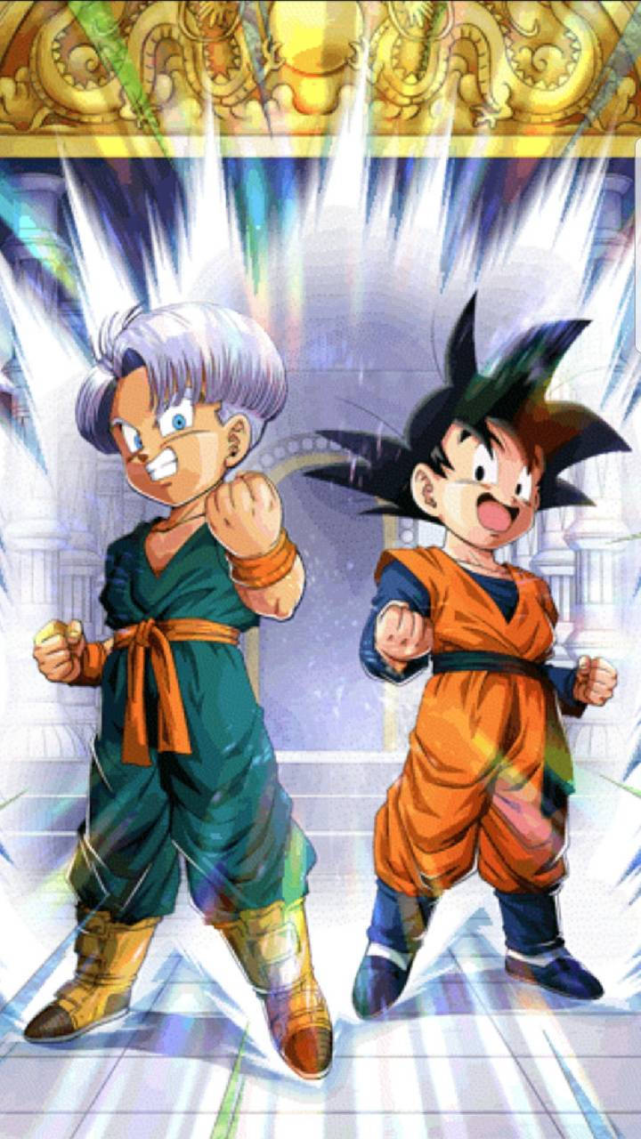 Goten 桌布 壁紙 — 兩位動漫戰士以戰鬥姿態散發能量，背景是金色華麗的背景和發光的光束。