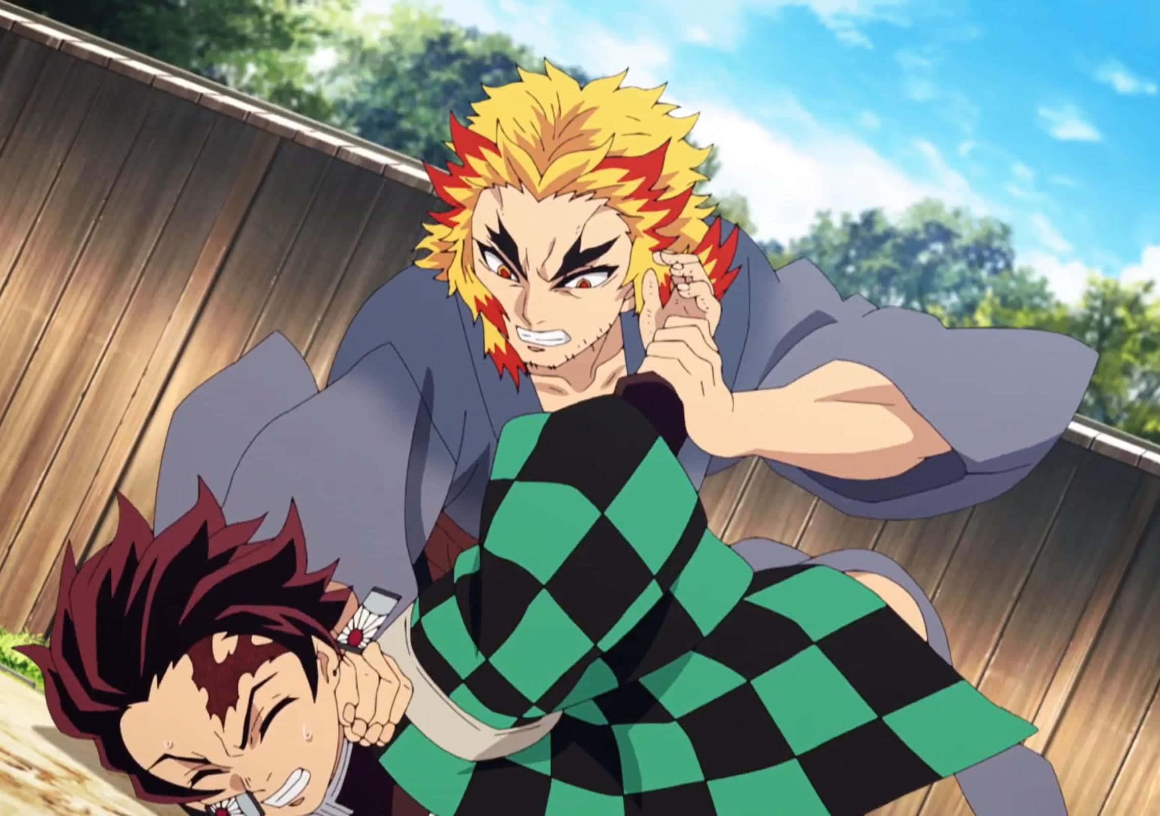 Rengoku And Tanjiro 桌布 壁紙 — 兩位動漫戰士在戶外激烈對戰，擁有鮮豔的綠色和紅色頭髮，背景是木柵欄和藍天。