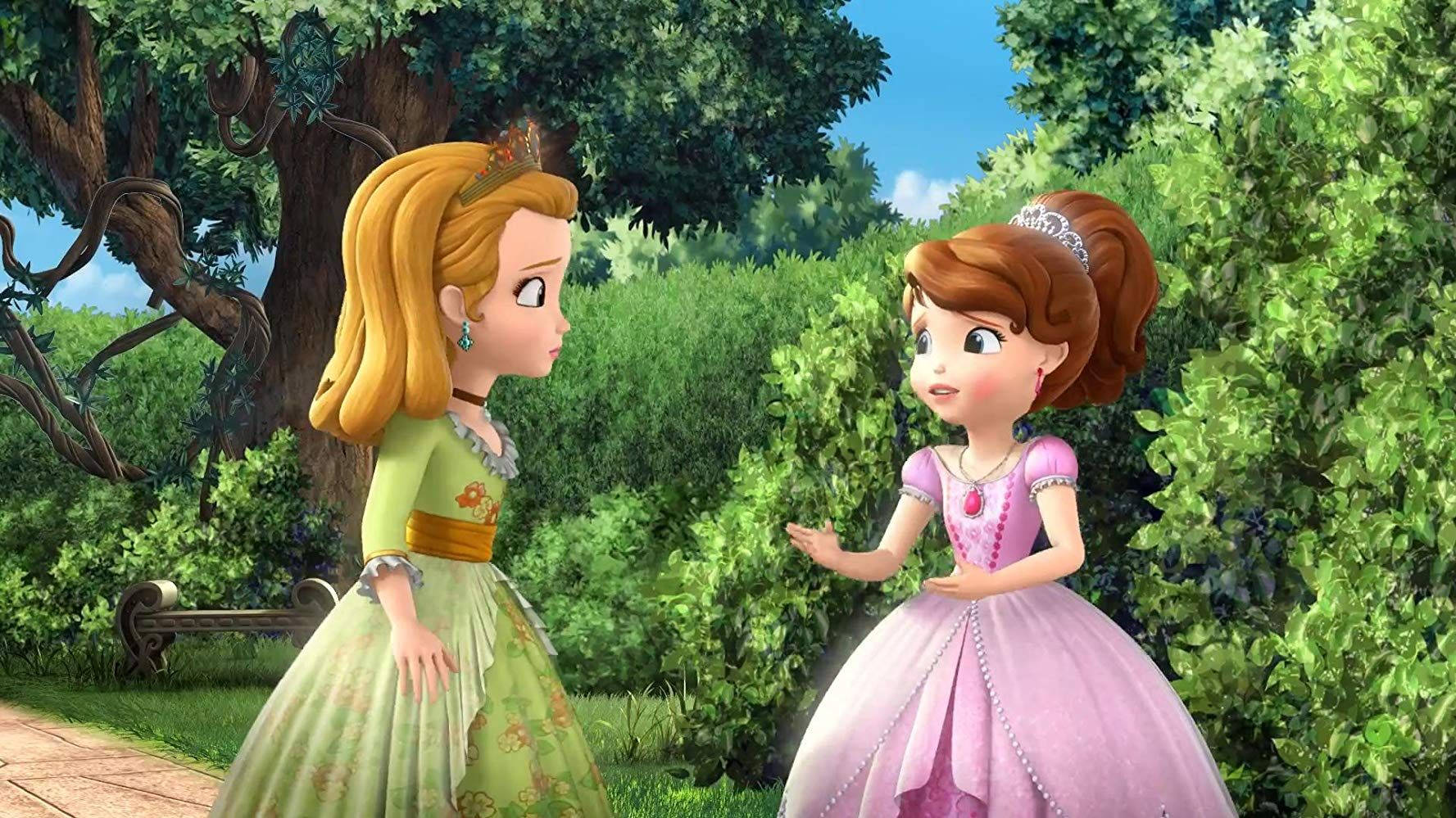 Princess 桌布 壁紙 — 兩位動畫公主穿著色彩繽紛的長裙，在陽光明媚的花園中交談，周圍環繞著茂密的綠植和石凳。