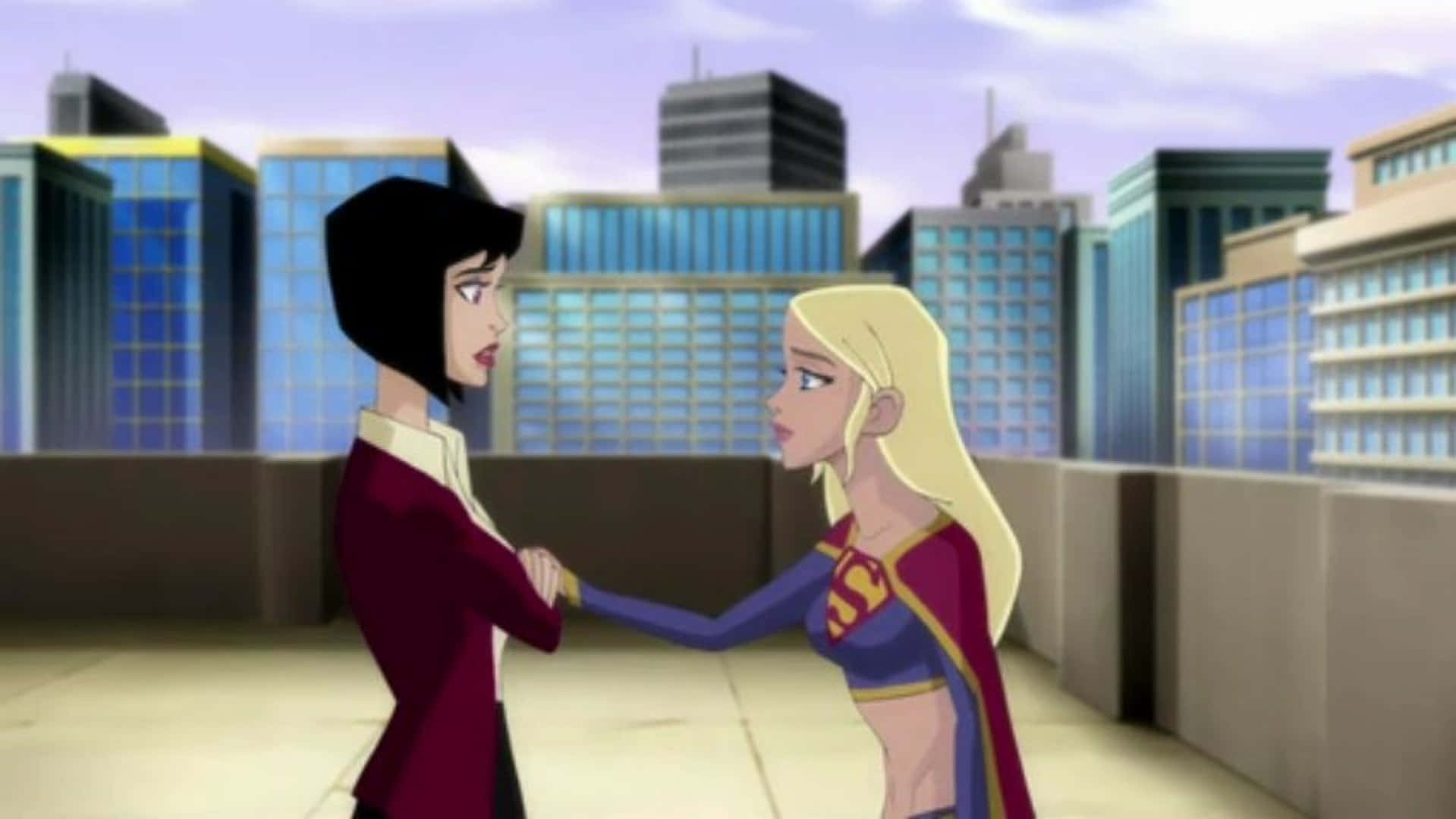 Superman Unbound 桌布 壁紙 — 兩位動畫女性超級英雄在摩天大樓背景下的城市屋頂上對峙。