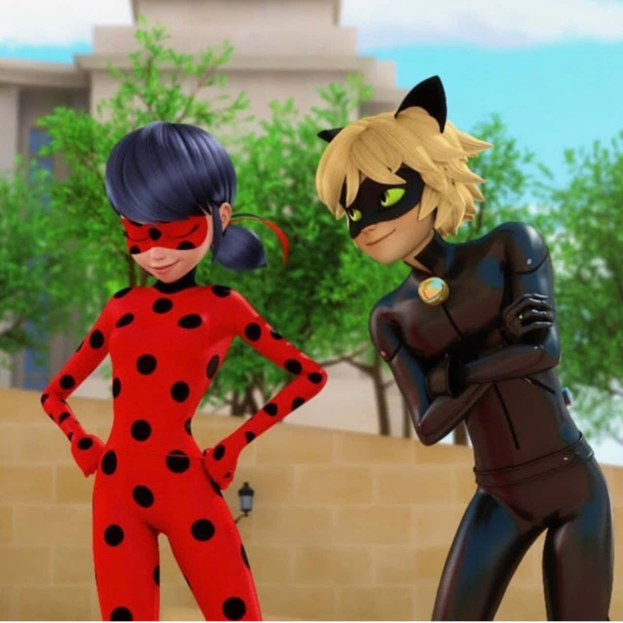Miraculous Ladybug And Cat Noir 桌布 壁紙 — 兩位動畫超級女英雄穿著紅色圓點和黑色貓女裝，自信地站在戶外，身後有綠樹和建築物。