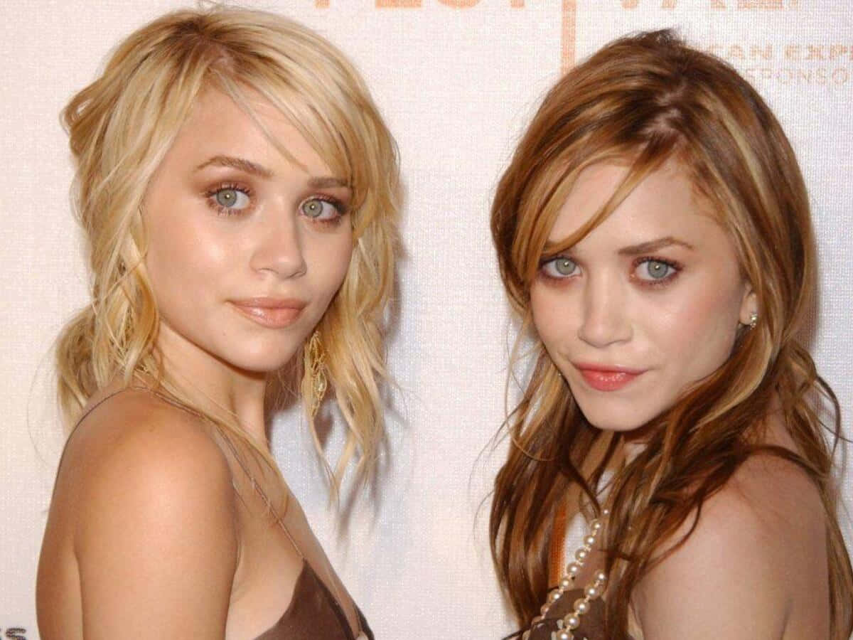 Mary Kate Olsen 桌布 壁紙 — 兩位同卵雙胞胎姊妹，擁有引人注目的藍色眼睛和波浪形金色與棕色頭髮，在正式活動中一起擺姿勢。