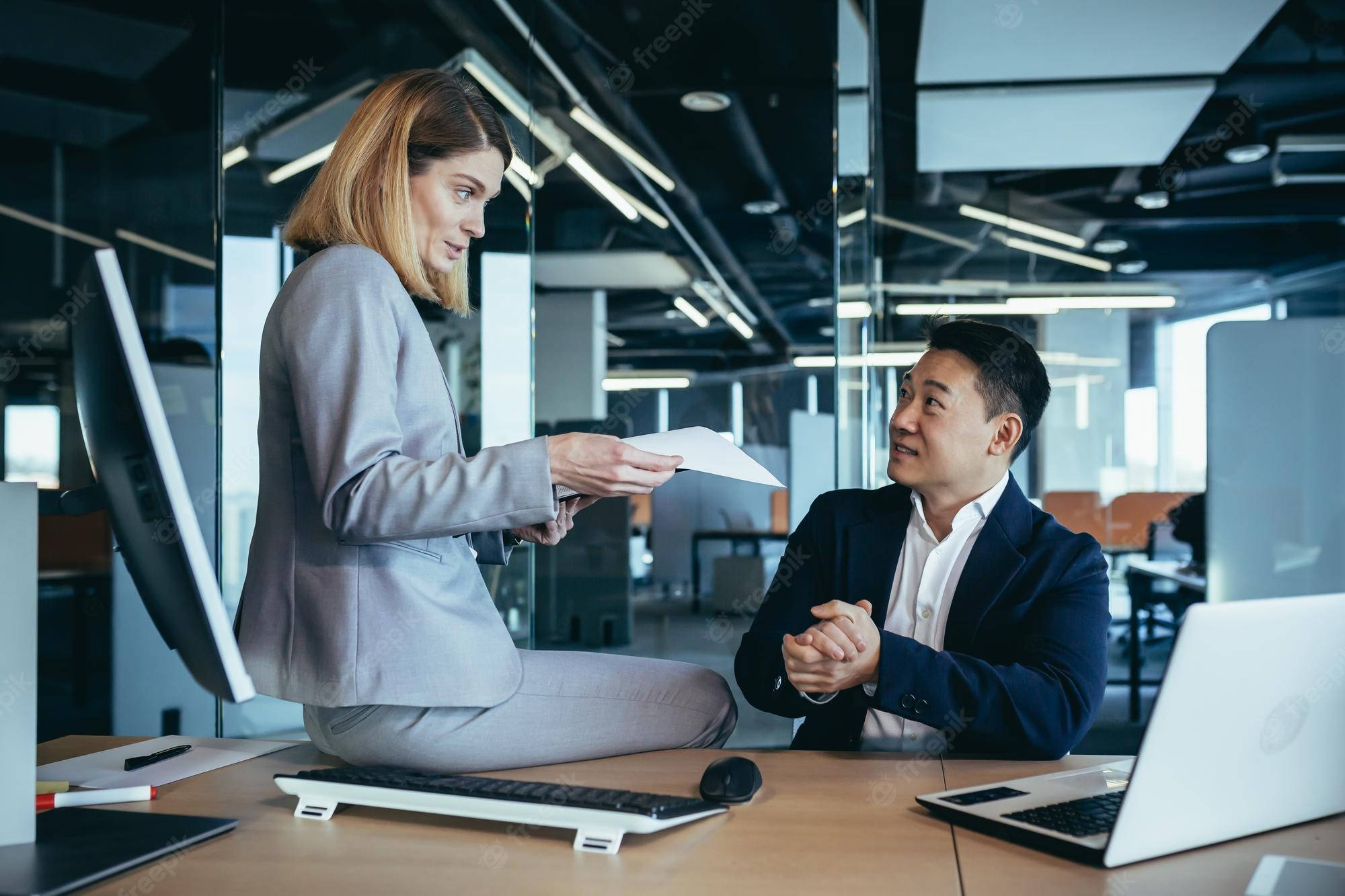 job 桌布 壁紙 — 兩位商業專業人士在現代開放式辦公室中就文件進行專注討論。