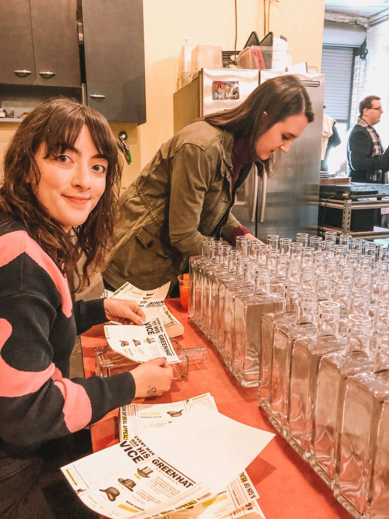 Gin 桌布 壁紙 — 兩位女士在廚房將液體裝入玻璃瓶，同時對著鏡頭微笑。