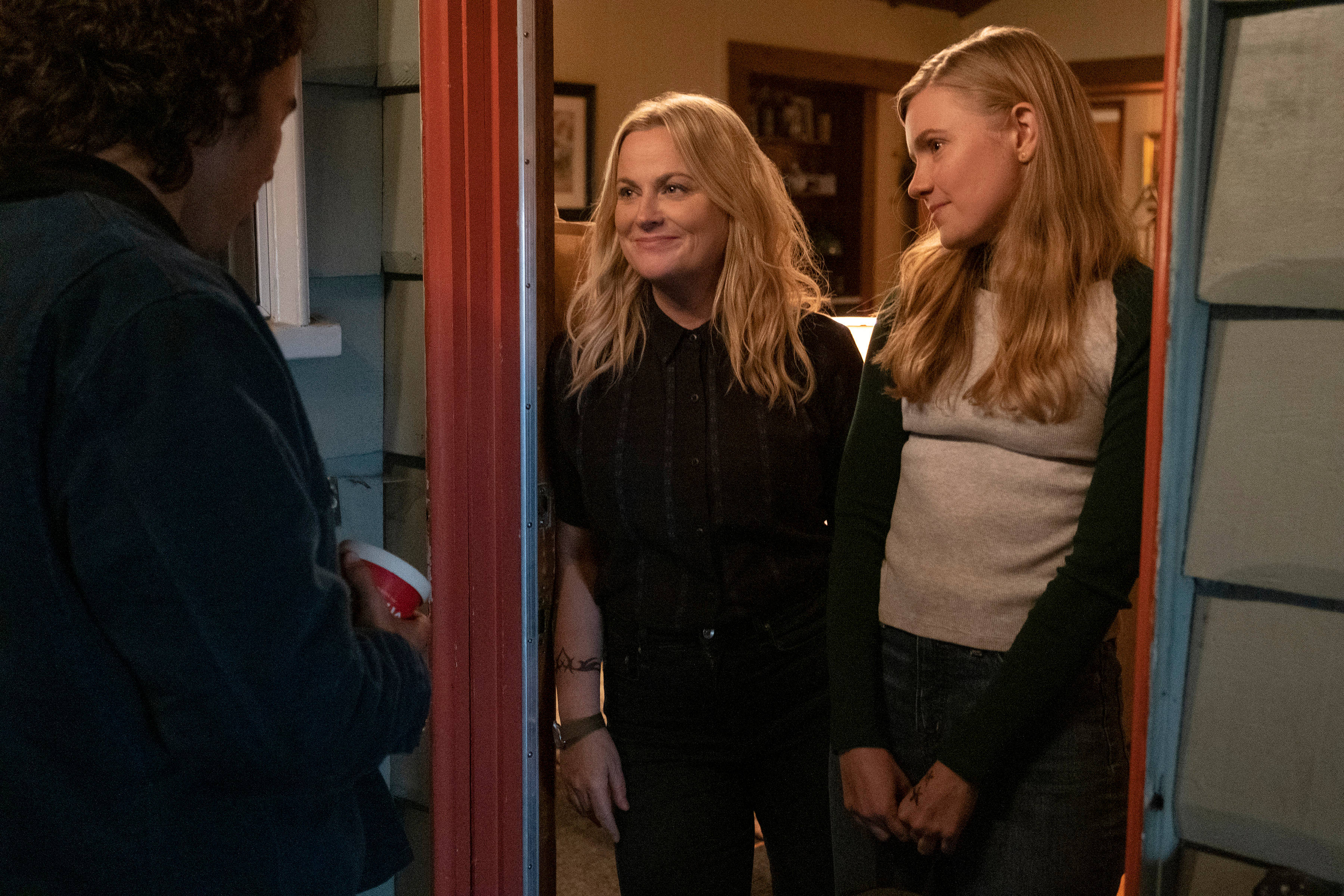 Netflix 桌布 壁紙 — 兩位女士站在門口，微笑著熱情迎接一位拿著紅色杯子的訪客。
