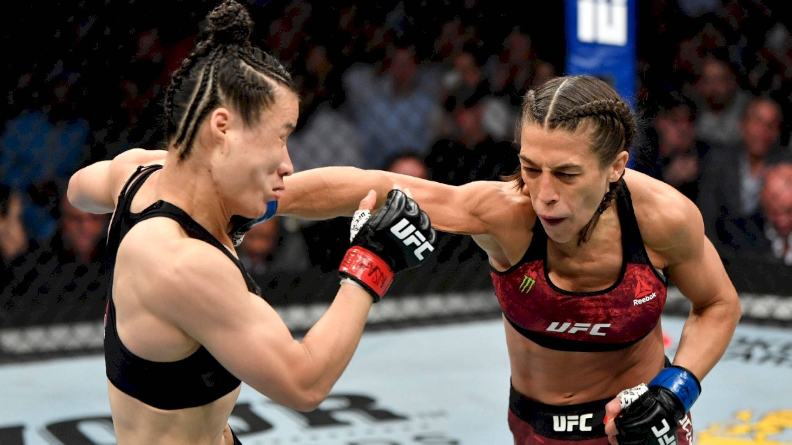 Punch 桌布 壁紙 — 兩位女性MMA拳手在明亮的場館燈光下，於UFC比賽中激烈交鋒。