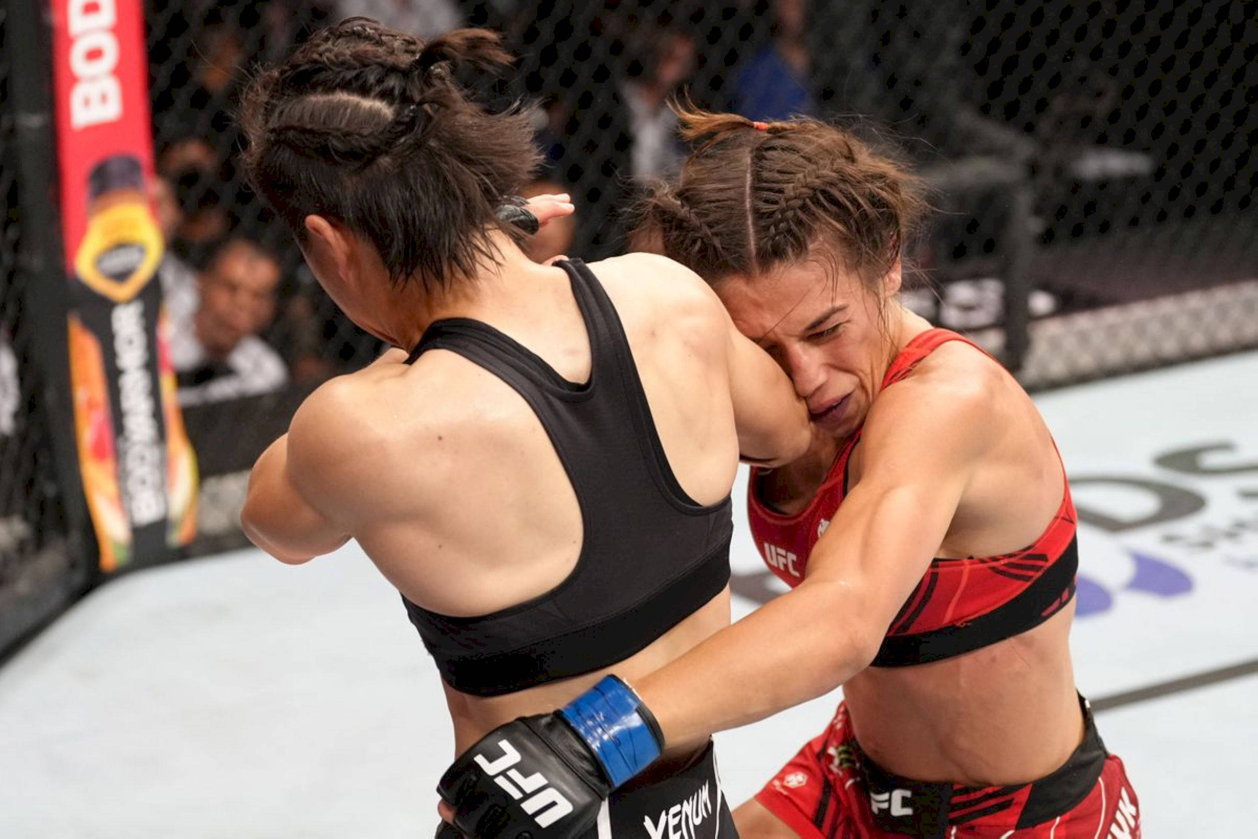 Athletic 桌布 壁紙 — 兩位女性MMA拳手在明亮的場館燈光下，於UFC比賽期間在鐵籠內激烈纏鬥。
