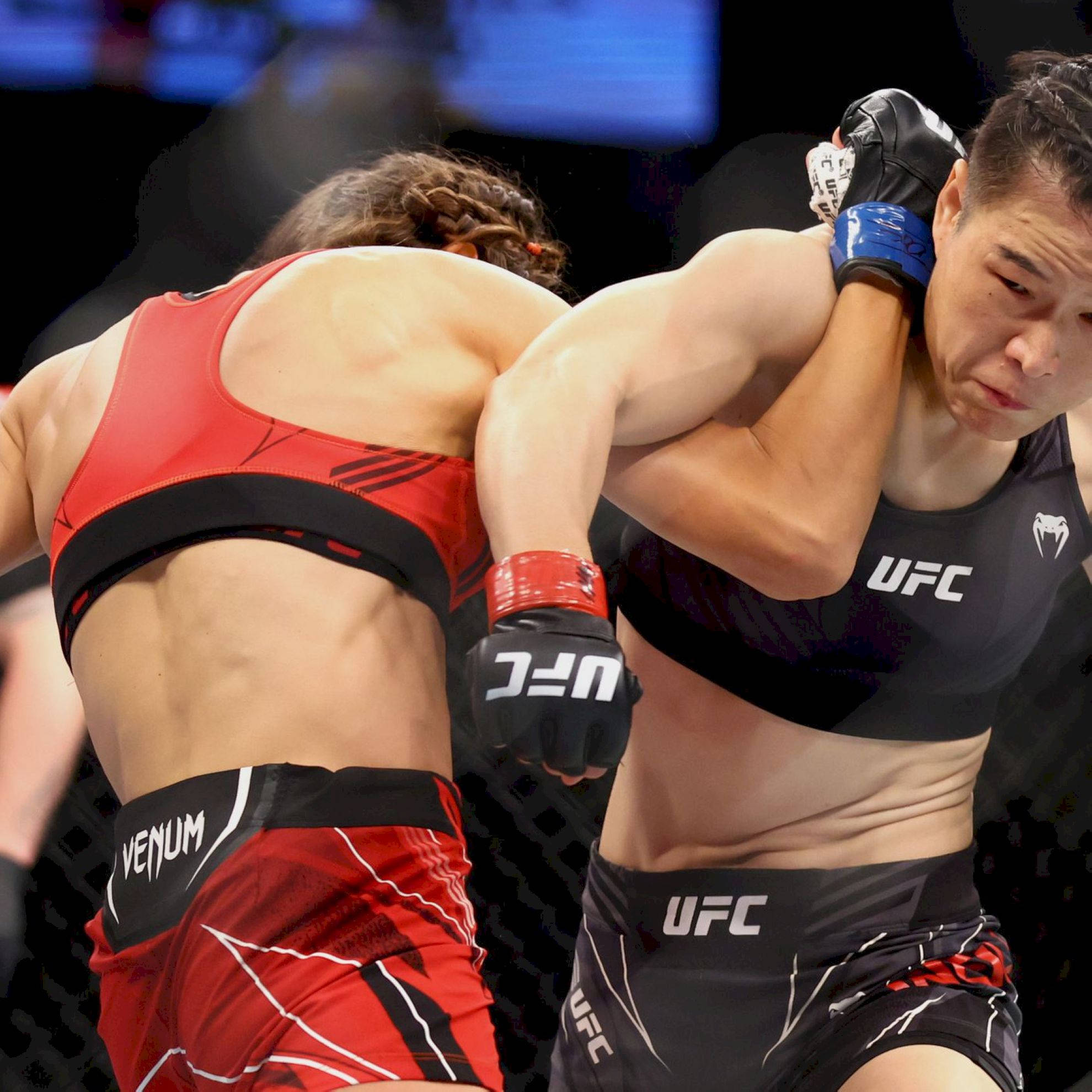 Punch 桌布 壁紙 — 兩位女性MMA拳手在明亮的場館燈光下，於UFC八角籠內激烈纏鬥。