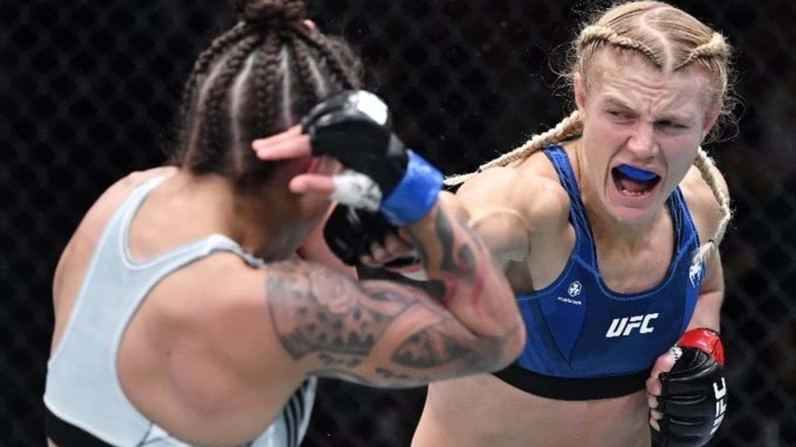 桌布 壁紙 — 兩位女性MMA拳手在激烈的鐵籠賽中，其中一人打出強力一拳。
