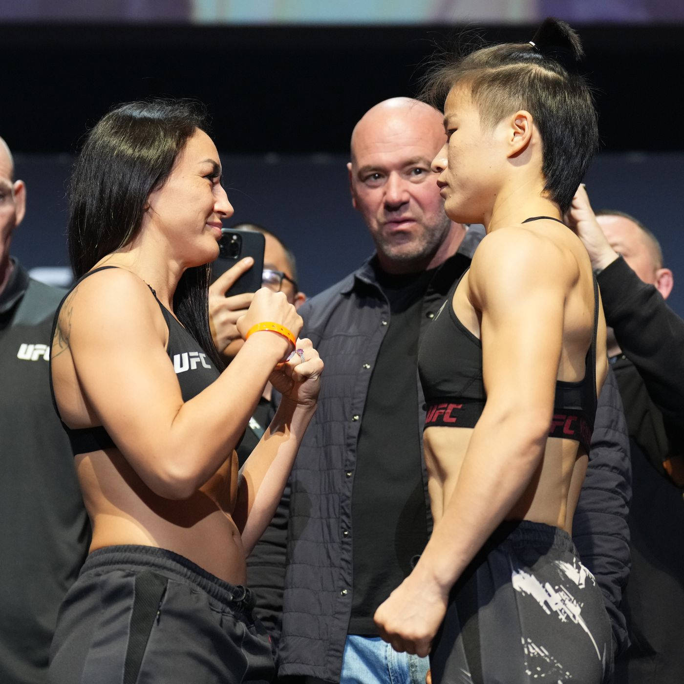 MMA 桌布 壁紙 — 兩位女性UFC拳手在明亮的場館燈光下，於賽前緊張對峙。