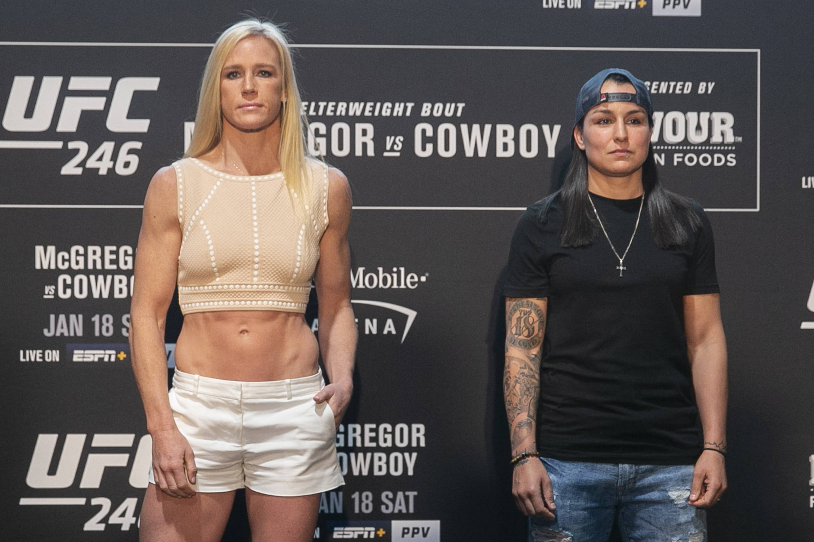 Strong Woman 桌布 壁紙 — 兩位女性UFC拳手在記者會上準備就緒，身後有宣傳橫幅。