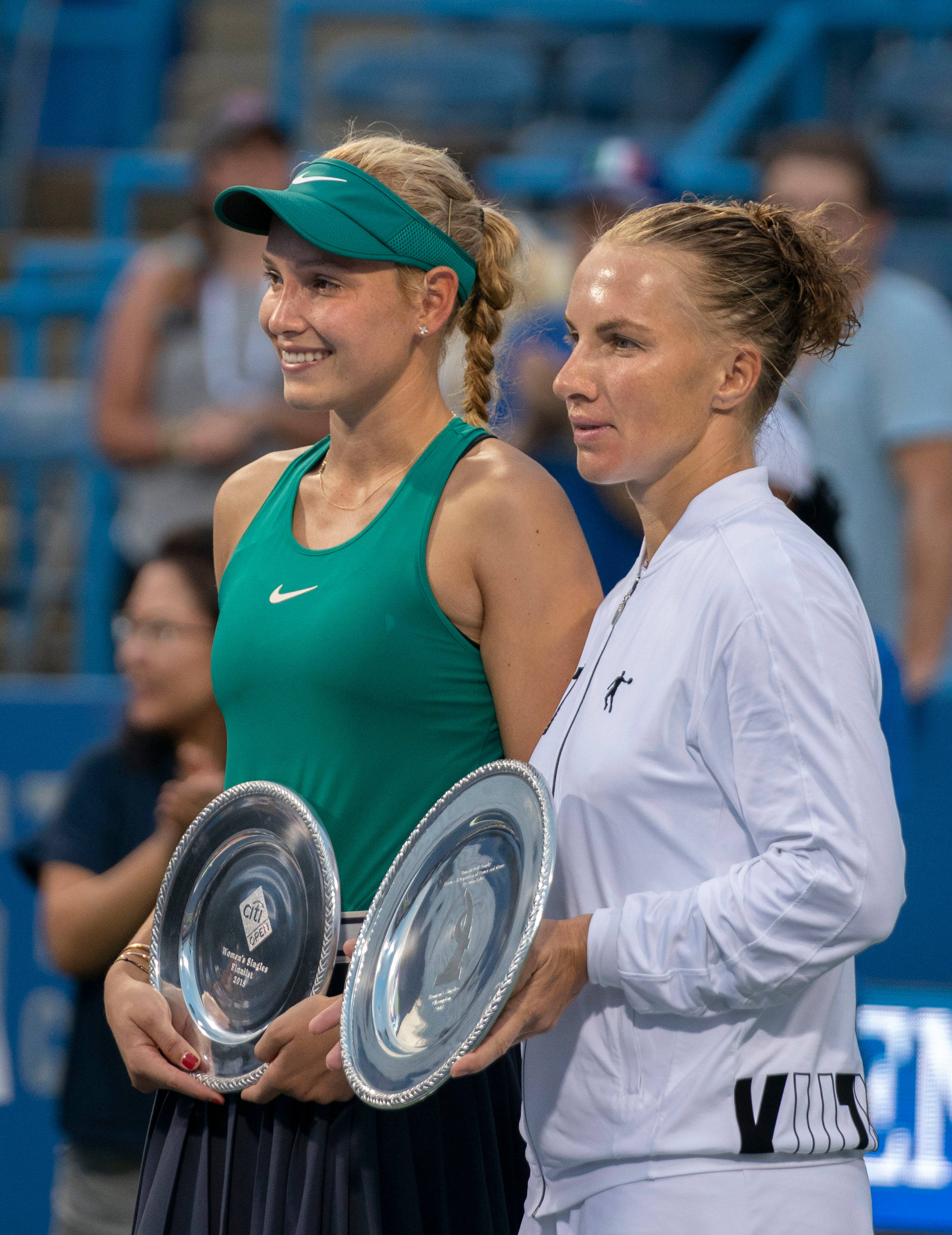 Svetlana Kuznetsova 桌布 壁紙 — 兩位女網球運動員並肩站立，在體育場燈光下手持銀色獎盃，露出燦爛笑容。