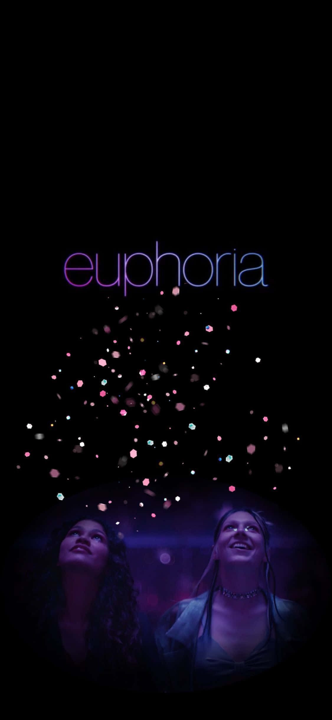 愉悅 桌布 壁紙 — 兩位年輕女性在發光的標題 euphoria 下驚奇地向上凝視，彩色粒子在黑暗中漂浮。