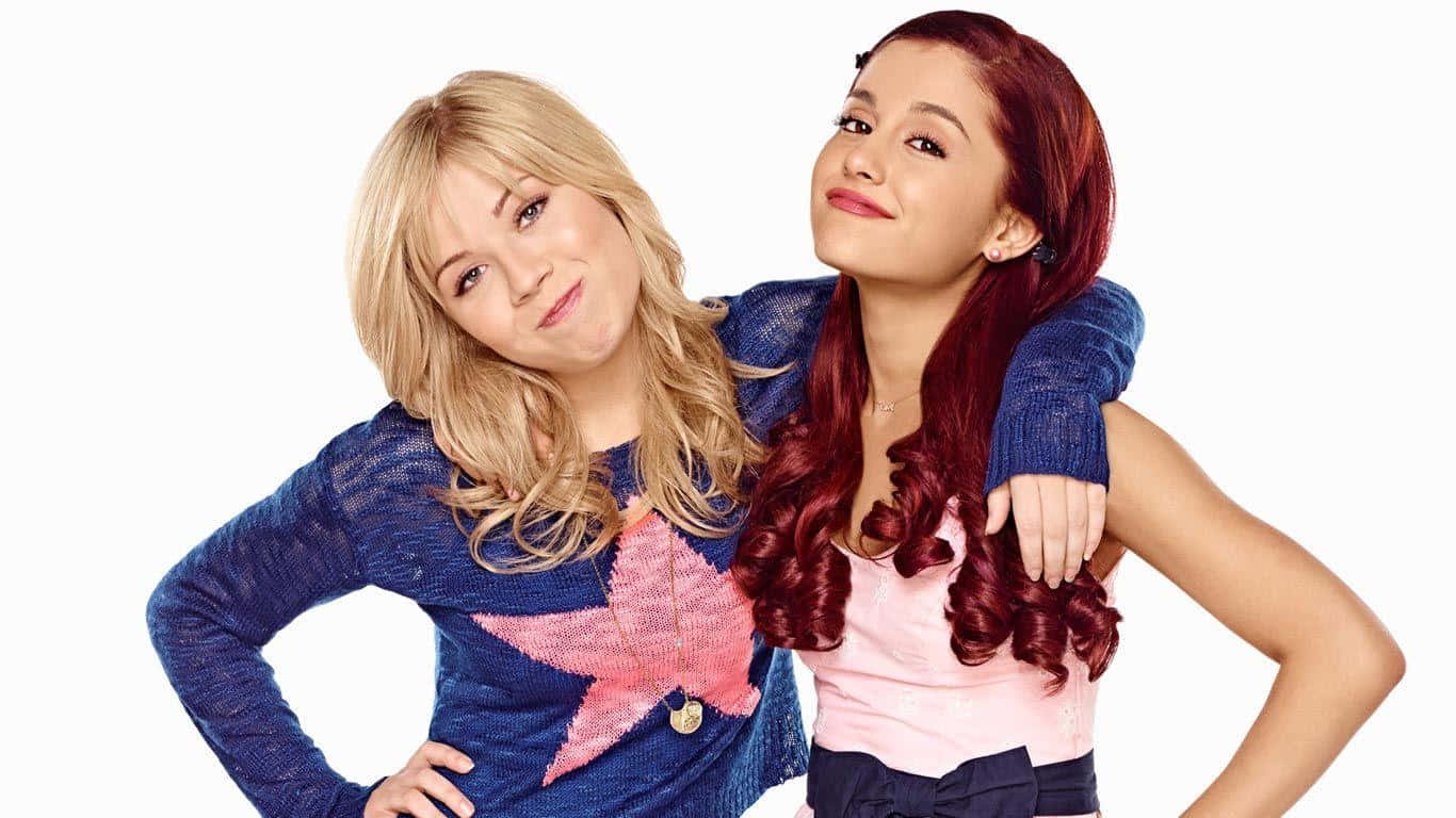 Sam And Cat 桌布 壁紙 — 兩位年輕女性在純白背景前俏皮擺姿勢，一位穿著藍色星星毛衣，另一位穿著粉紅色上衣，紅髮。