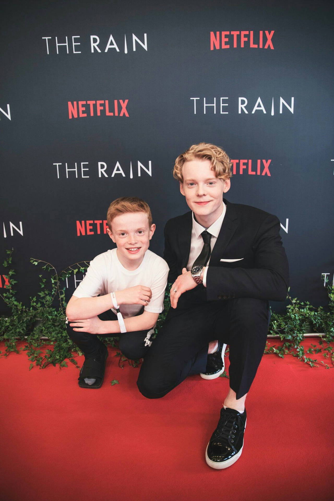 兩位年輕演員在 Netflix 的 The Rain 活動中一起在紅地毯上擺姿勢。 — 下雨 GIF 壁紙