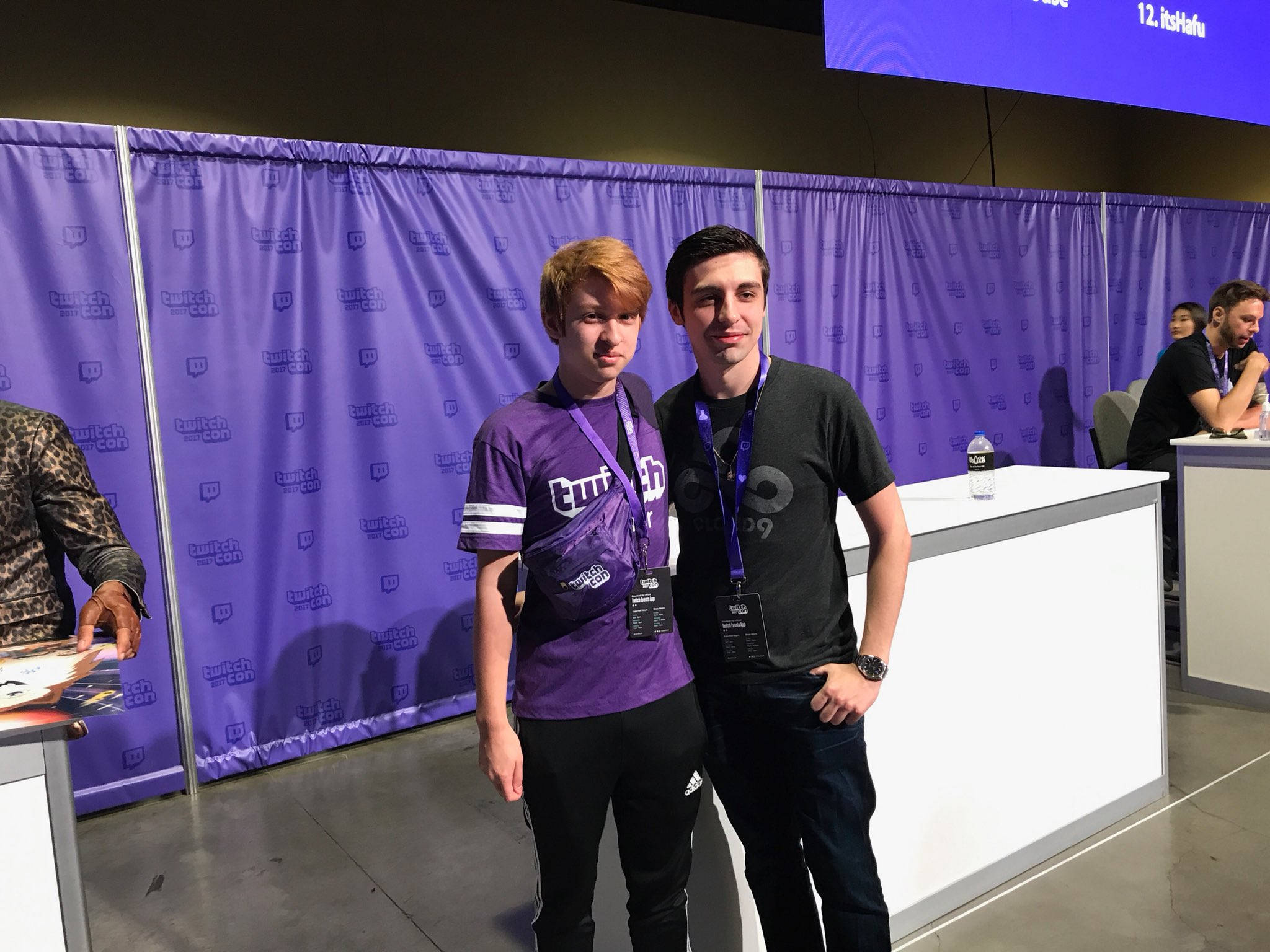 Shroud 桌布 壁紙 — 兩位年輕男子在TwitchCon活動中，在紫色品牌背景和活動標誌下拍照留念。