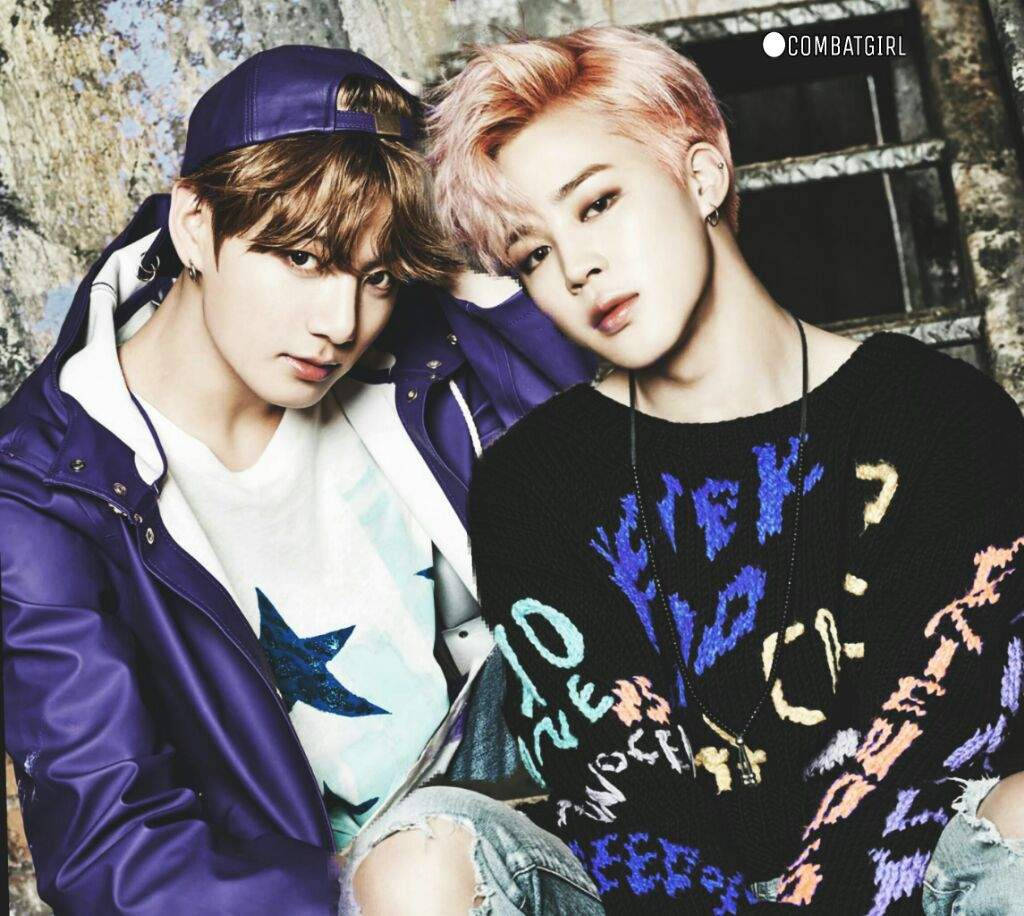 Jikook 桌布 壁紙 — 兩位年輕男子帶著造型頭髮，緊靠著風化的磚牆，穿著大膽的紫色和圖案毛衣擺姿勢。