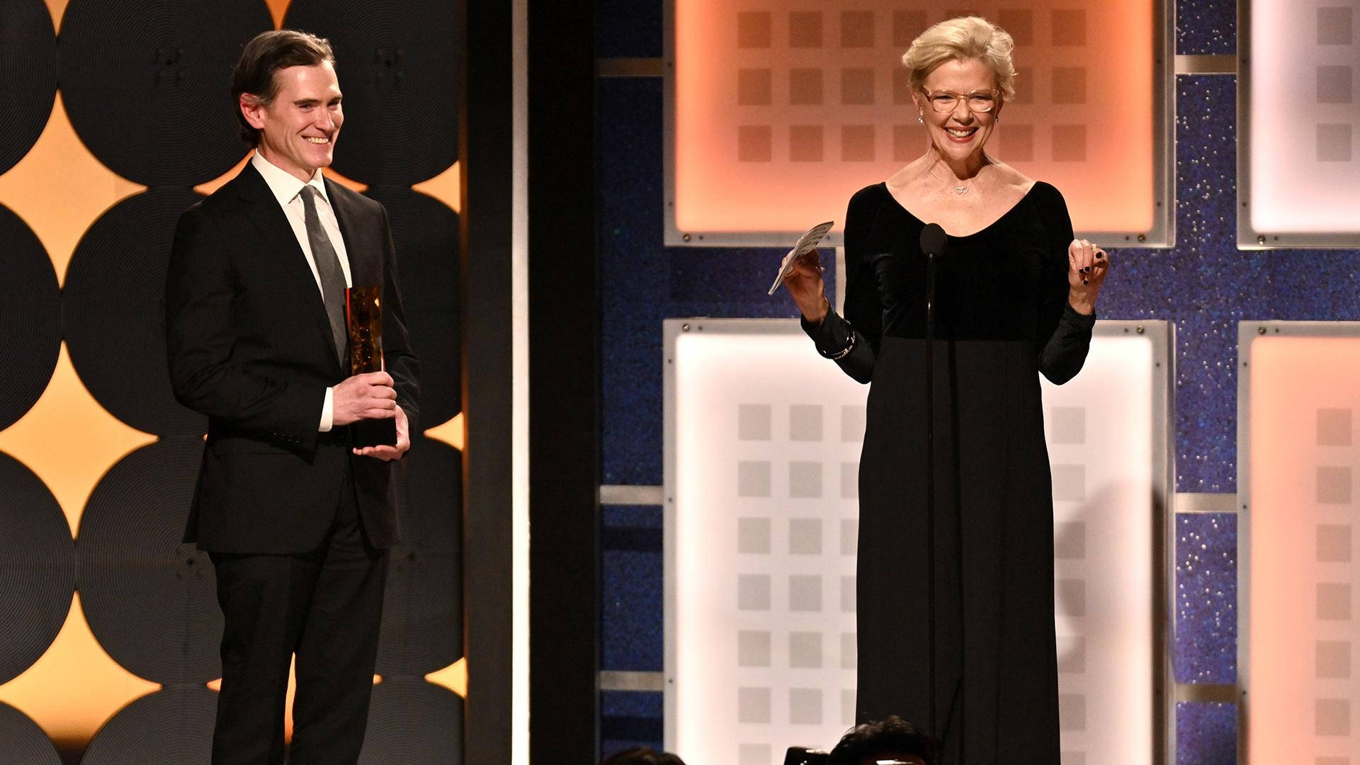 Celebrity 桌布 壁紙 — 兩位得獎者在幾何圖案背景的舞台上微笑，手持獎盃。